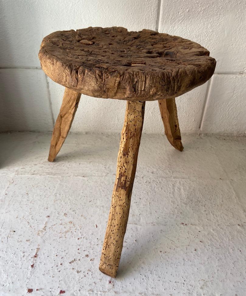 Antique hardwood stool from San Felipe, Guanajuato, circa 1910. This Primitive styled stool shows a significant amount of ware from heavy use as well as the elements. The legs were at one point replaced, however cut in the traditional manner by way