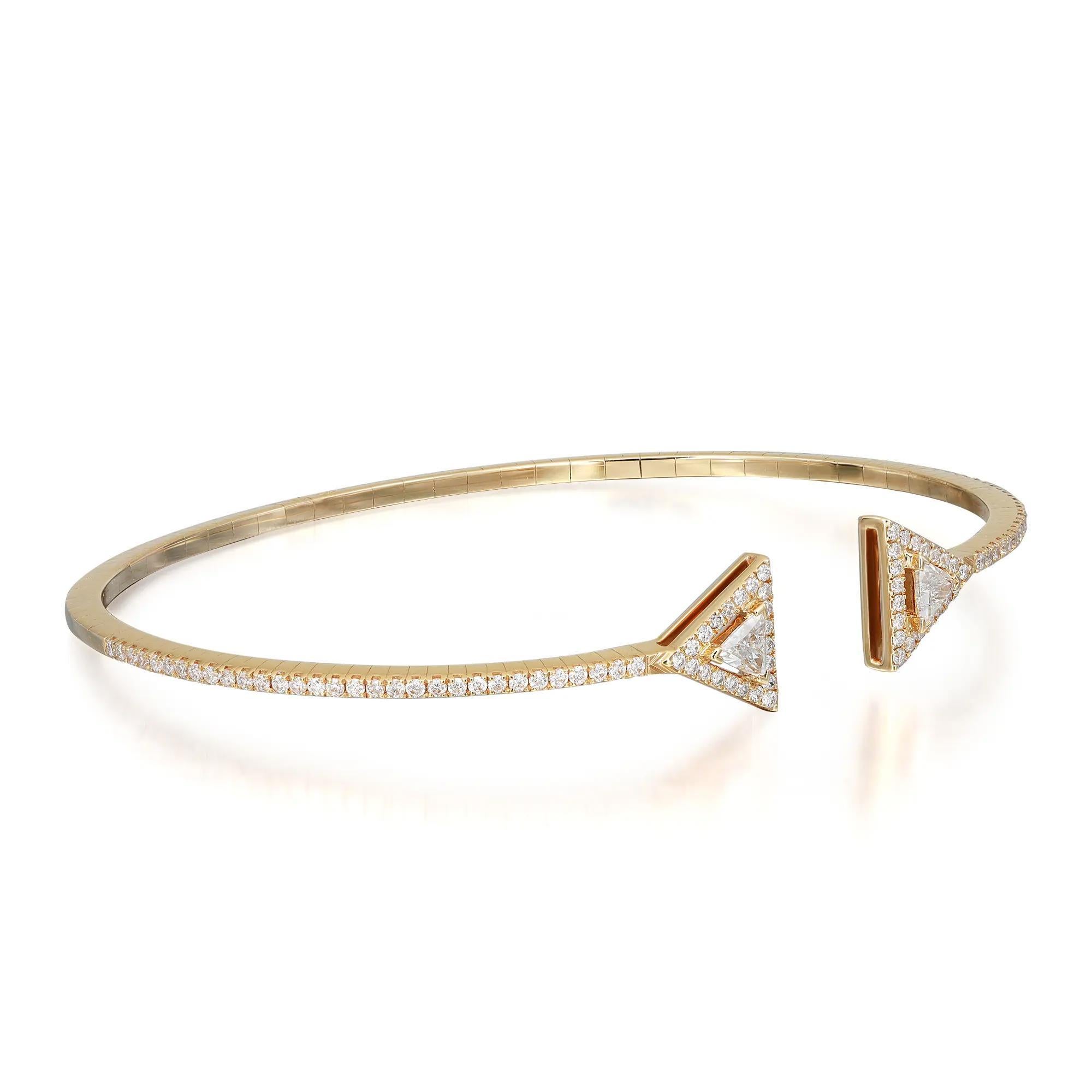 This exquisite Messika Thea Skinny diamond cuff bracelet features 2 prong set triangular cut diamonds with a halo of round brilliant cut diamonds accented halfway through the bracelet. Crafted in 18K yellow gold. Feminine and super stackable modern