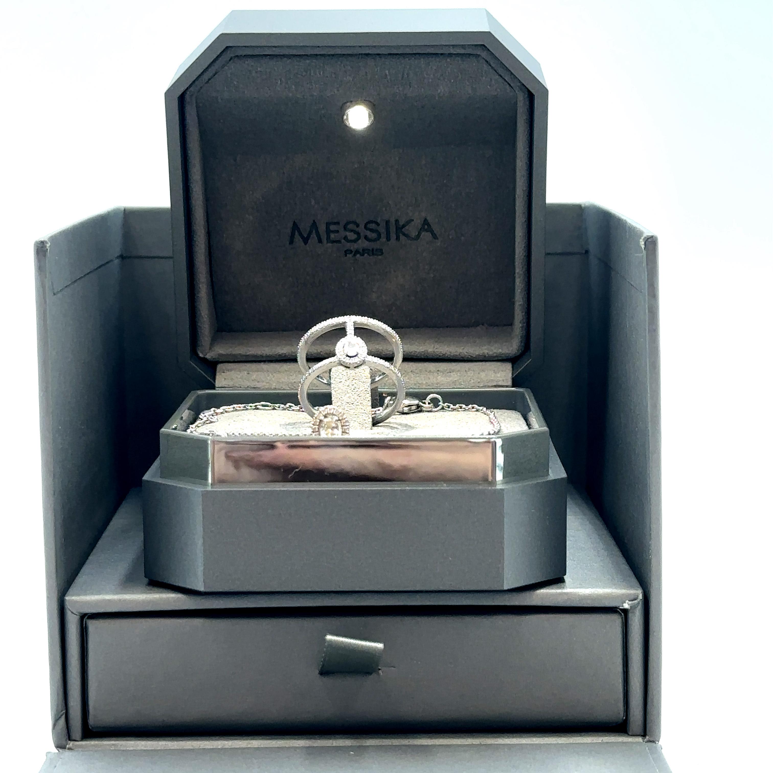 Messika 18k white gold bracelet witha central claw set opal shaped diamond and matching double banded ring set with a central oval shaped diamond. Ring is a size 5.5 and total weight of both items is 7.7 grams. Comes with original box and booklet.
