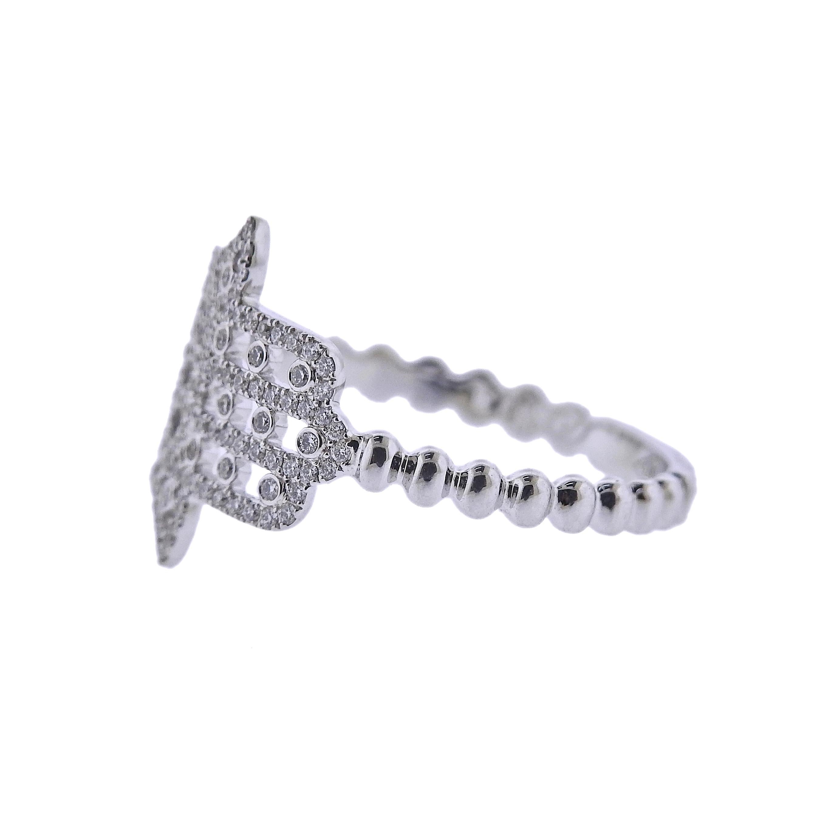 18k white gold Faith collection hamsa ring by Messika, set with 0.24ctw G/VS diamonds. Retail  $2,800. New with original box. Rings top measures 15mm x 14mm. Available in sizes 6.25 and 6.75. Weight - 2 grams. Marked: Messika, 750.