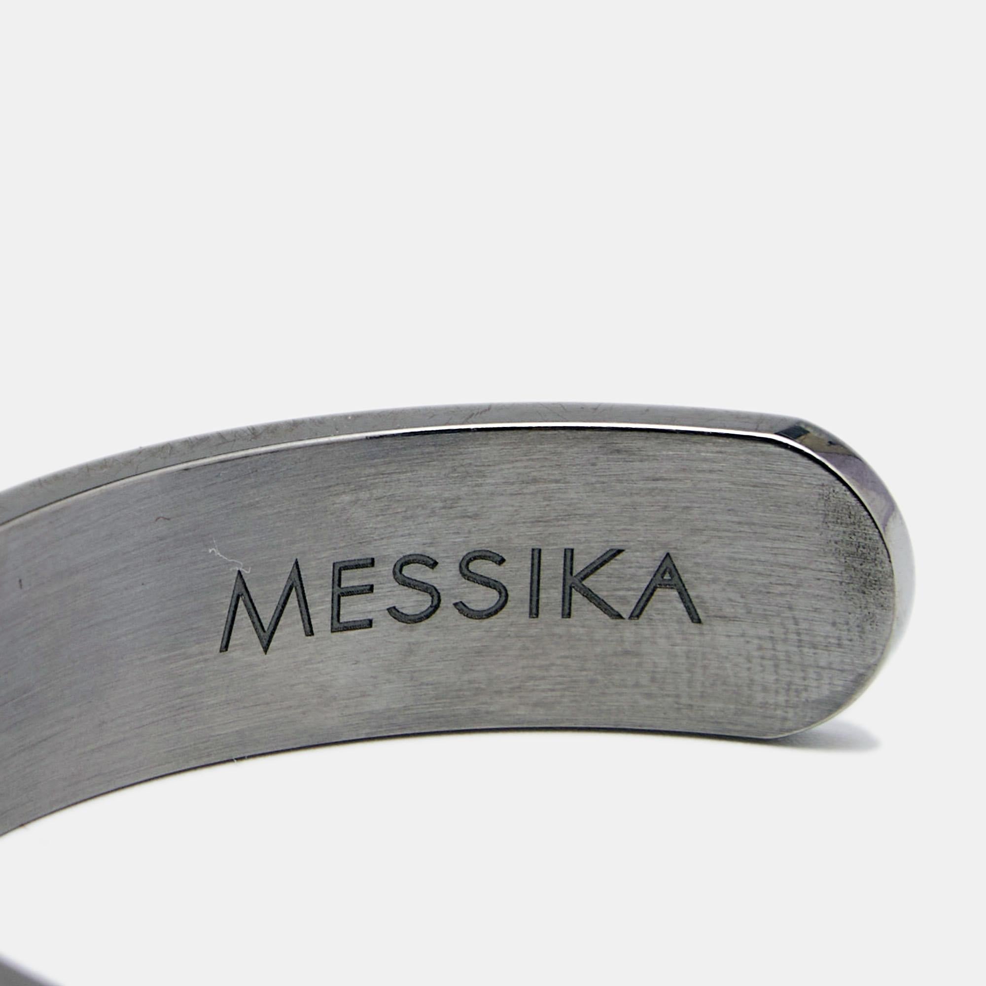 Move is an iconic collection of house Messika, a line that embodies elegance in simple designs. This bold bracelet is crafted from titanium into an open cuff silhouette and centered with a cage that holds three diamonds.

Includes: Original Box,