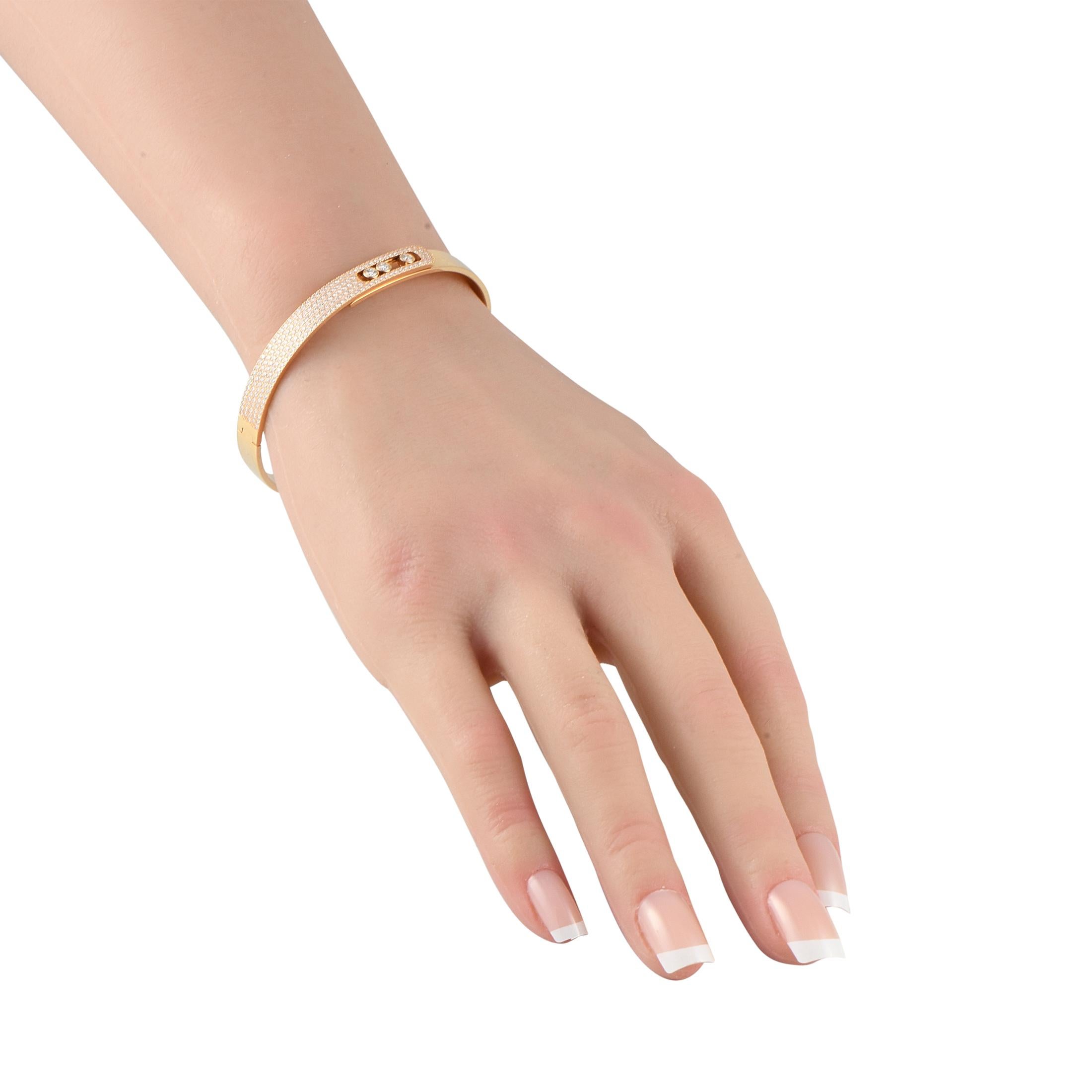 This Messika Move Noa bracelet is an iconic piece that exudes contemporary luxury. Crafted from opulent 18K Yellow Gold, this semi-pav variation radiates light thanks to Diamonds with a total weight of 1.20 carats. At the center, a trio of brilliant