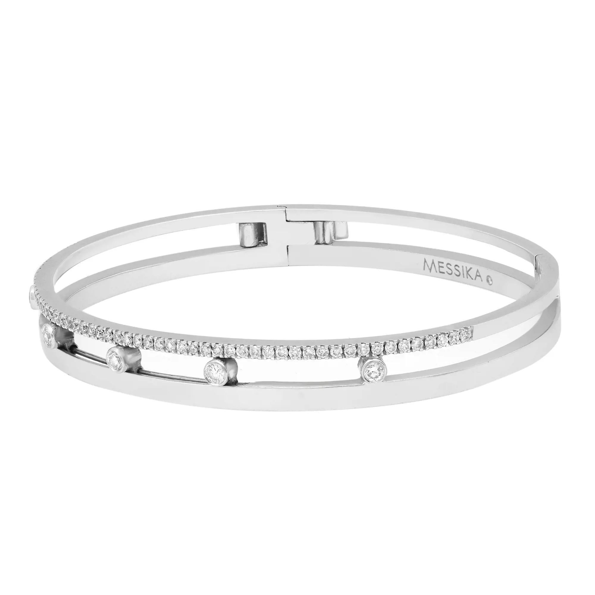 This Messika Move Romane luxury jewelry collection balances the shimmering of solid gold and the lightness of a diamond strand. Crafted in fine 18K white gold. An openwork bangle with modern asymmetry is balanced with five bezel set round brilliant