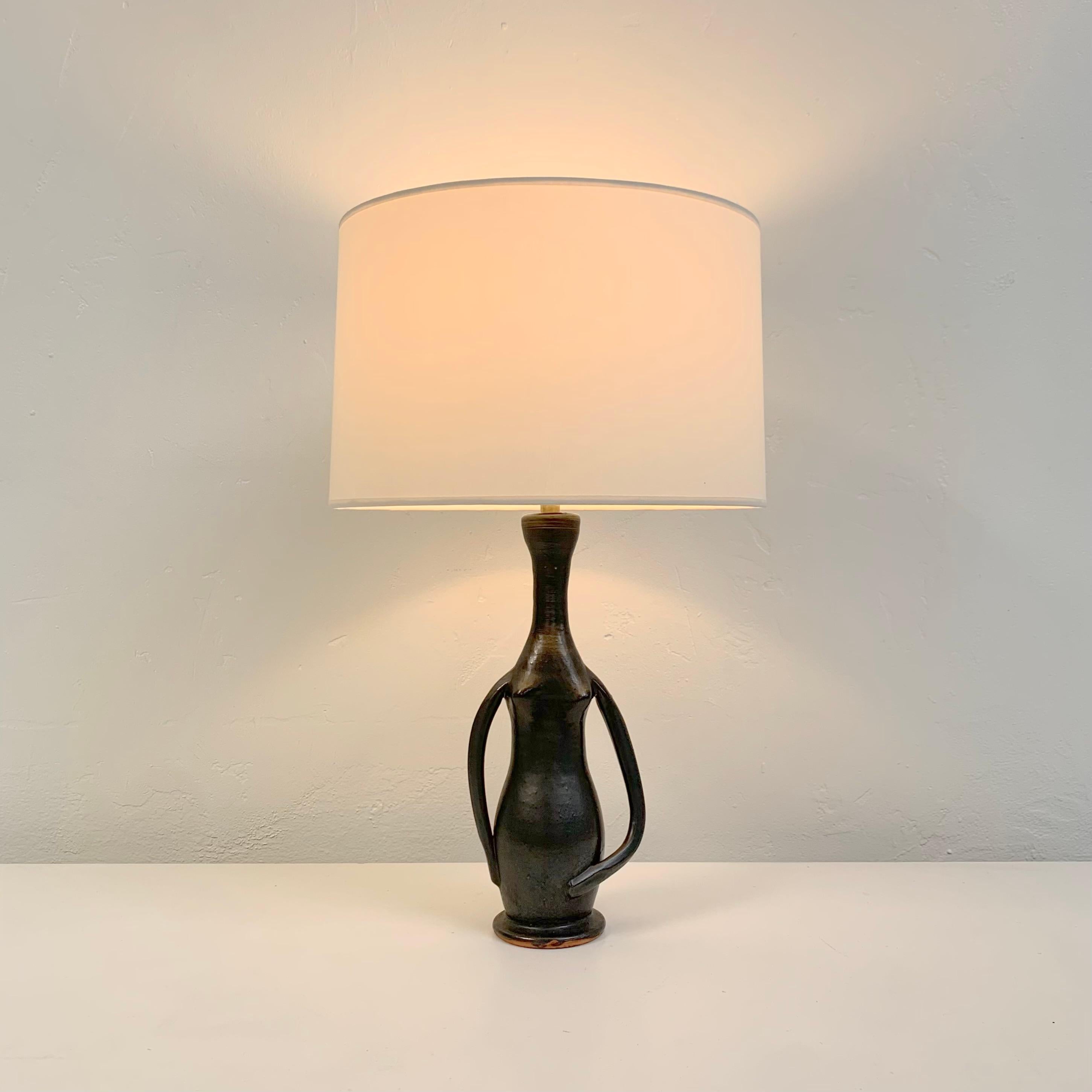 Schöne antropomorphe Tischlampe von Guillaume Met De Penninghen, um 1950, Frankreich.
Schwarz emaillierter Sandstein.
Abmessungen: 52 cm Gesamthöhe, Durchmesser des Schirms: 32 cm.
Höhe der Keramik ohne Schirm: 32 cm. 
Seltene Keramik in gutem