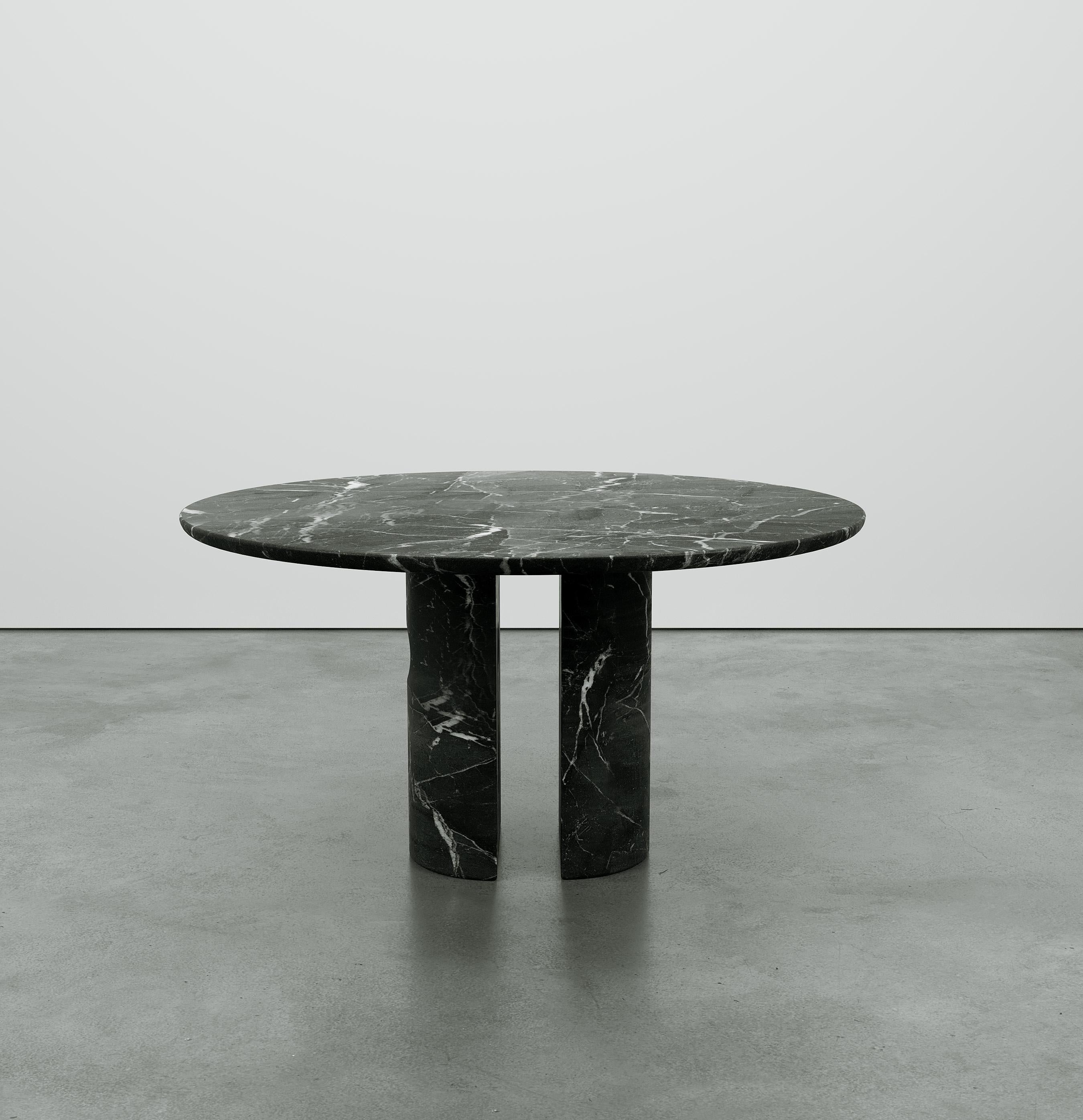 Inspired by Euclidean geometry, the Meta table expresses a balance of simplicity and elegance that evokes a combination of raw and primitive qualities. The monolithic style legs are cut from a single block of stone to form two semi-circular columns