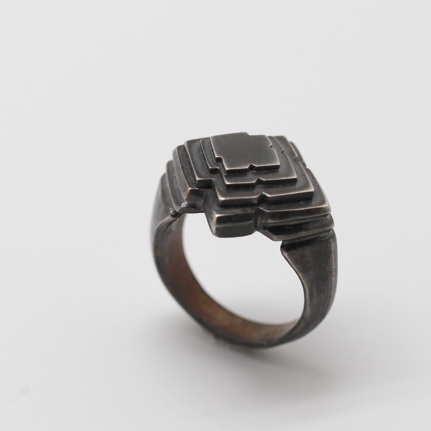 Geometric shapes incrementally repeat and taper in an homage to micro-structural phenomenons in nature and in ancient architecture in the Ziggurat Ring by Metaalia Jewelry. Cast and hand fabricated in sterling silver, oxidized. 

Size is 9.75. This