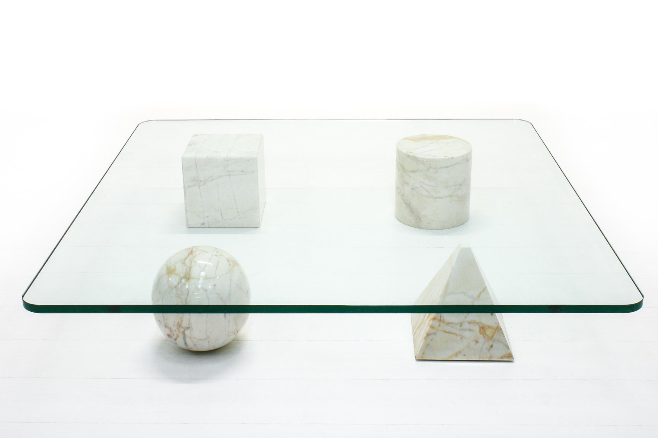 Designed in 1979 by Massimo and Lella Vignelli, this coffee table consists of a heavy glass top and four geometric figures that serve as feet - these are entirely in marble. They can be arranged at will.