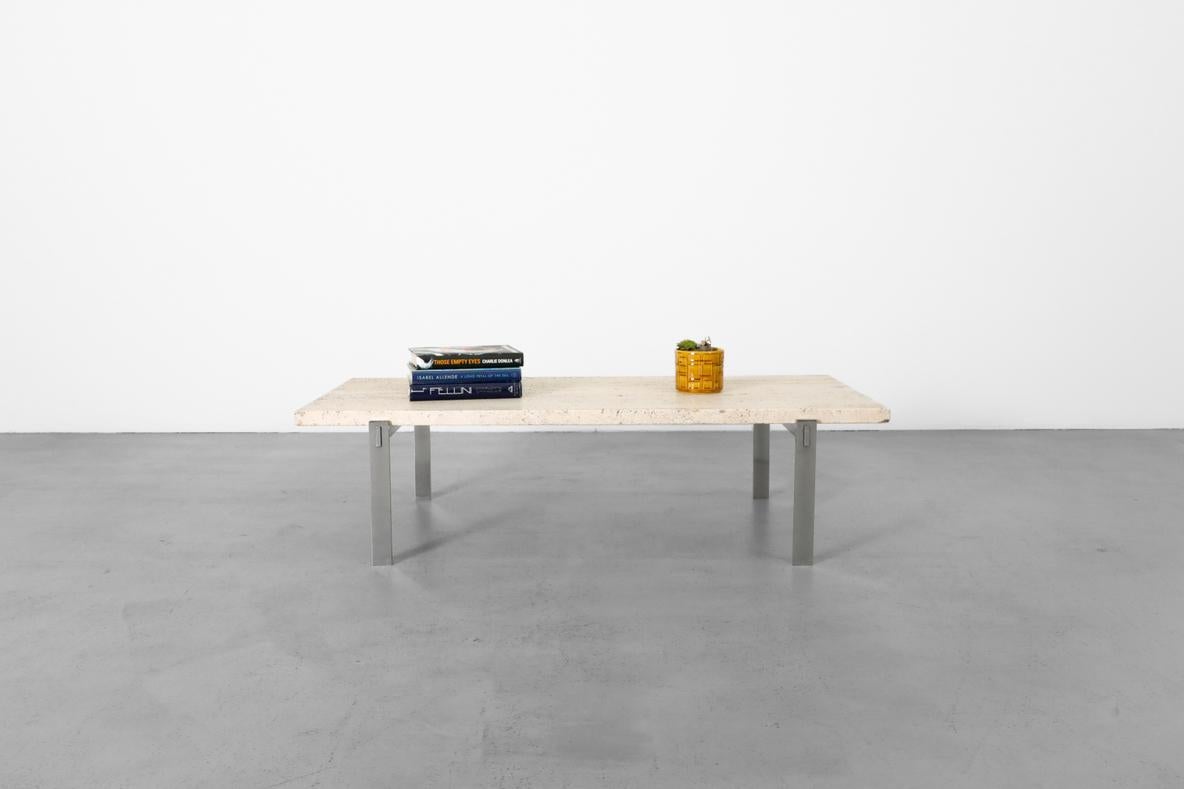 Table basse à cadre chromé d'inspiration Metaform avec un épais plateau rectangulaire en travertin, rappelant les tables en pierre et en acier de Poul Kjaerholm. En état d'origine avec quelques rayures et pertes visibles sur le cadre ainsi qu'une