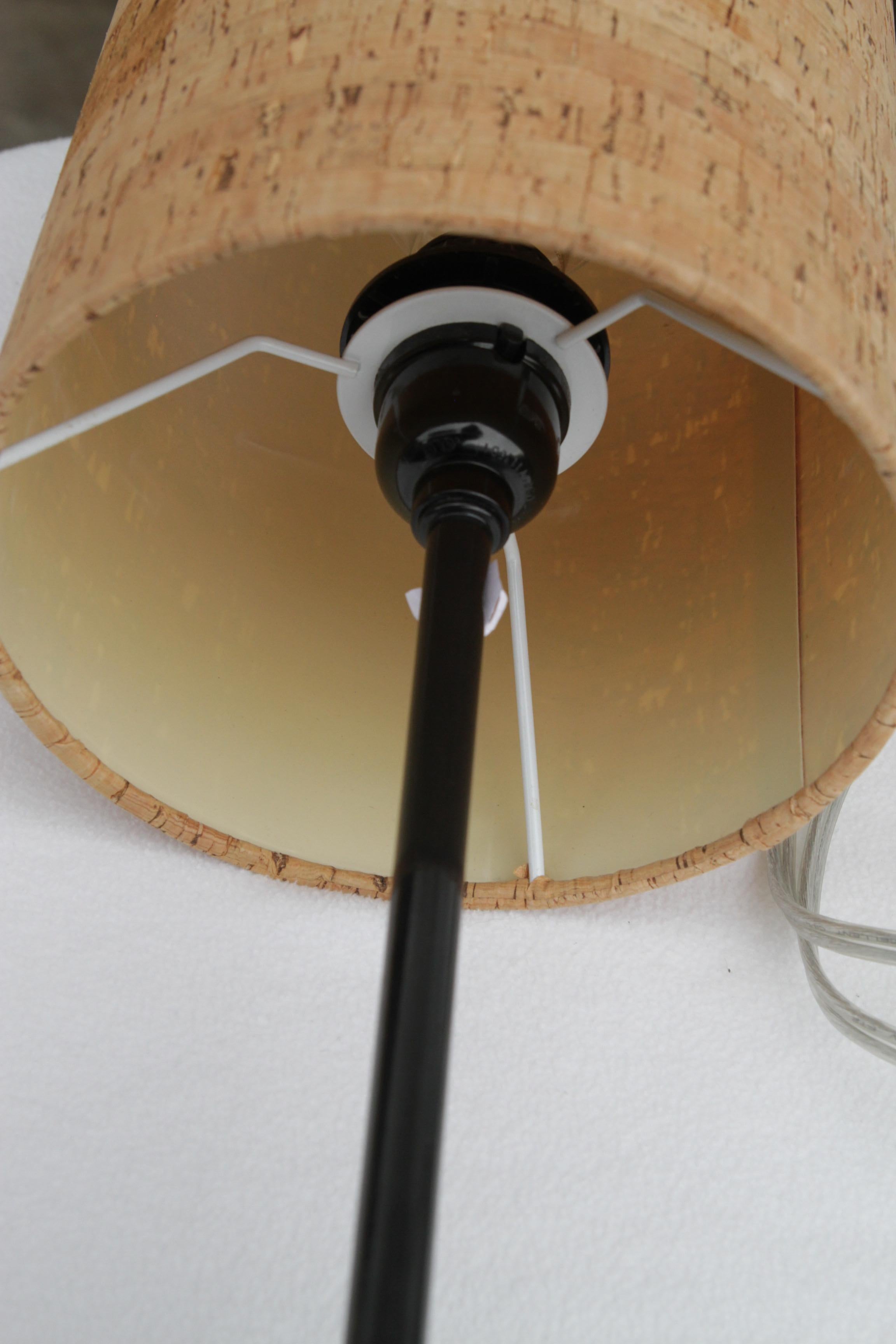 Le lampade d'accento in metallo con paralumi a vite in sughero hanno un'estetica pulita e minimalista, che combina elementi naturali e industriali per un look equilibrato ed elegante. Ogni lampada è progettata con un paralume cilindrico in sughero,