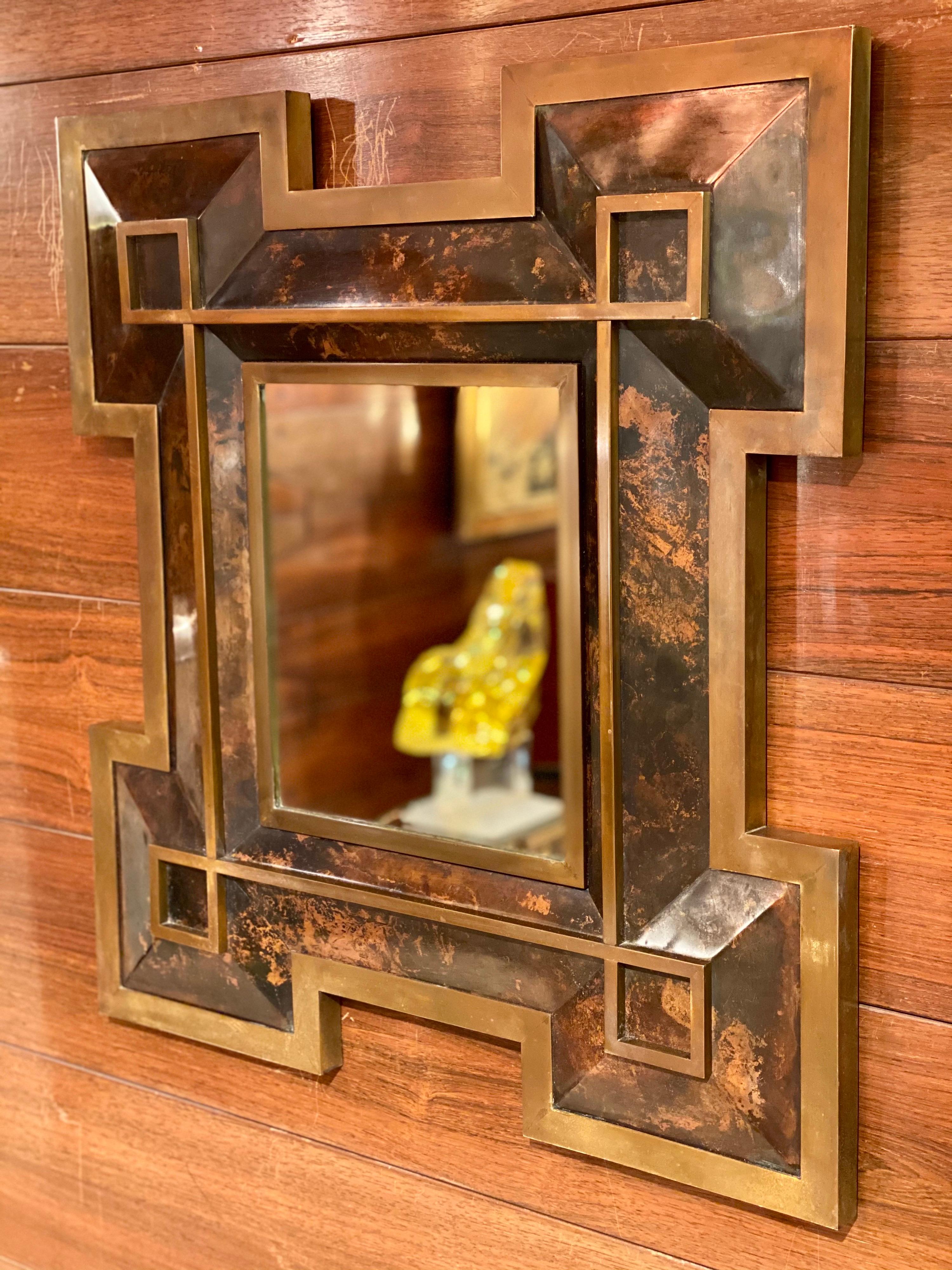 Neoclassical mirror in metal and brass by Maison Jansen, 1970's. High quality workmanship with thick brass detail and beautiful patina.