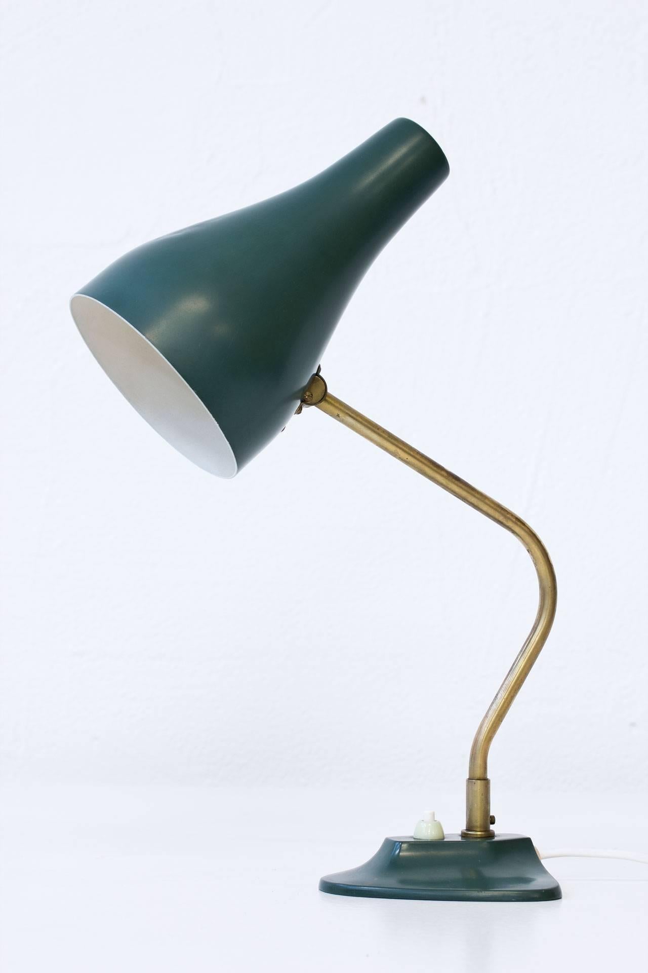 Swedish table lamp manufactured by ASEA during the 1950s. 
Brass stem with diffuser and base in green painted metal. 
Adjustable shade and axis. Signed on bottom.