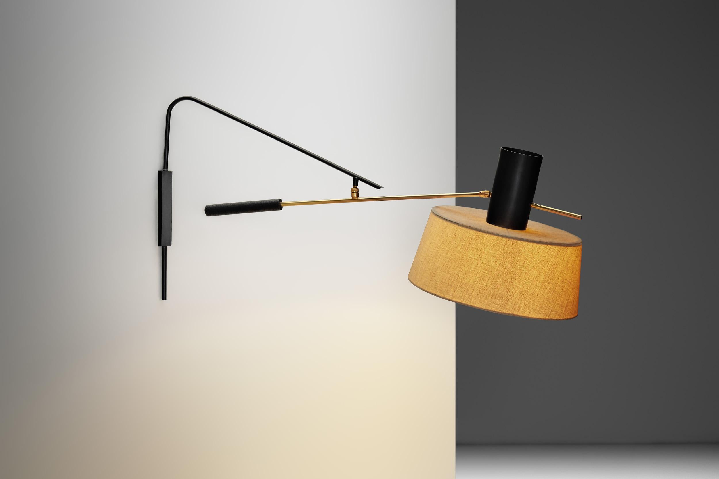 Fabriquée à la manière de la Maison Silhouette, cette lampe murale présente une silhouette sculpturale saisissante et illustre le mariage de la fonction et de la forme à cette époque. Avec une combinaison de laiton et de métal laqué noir, il