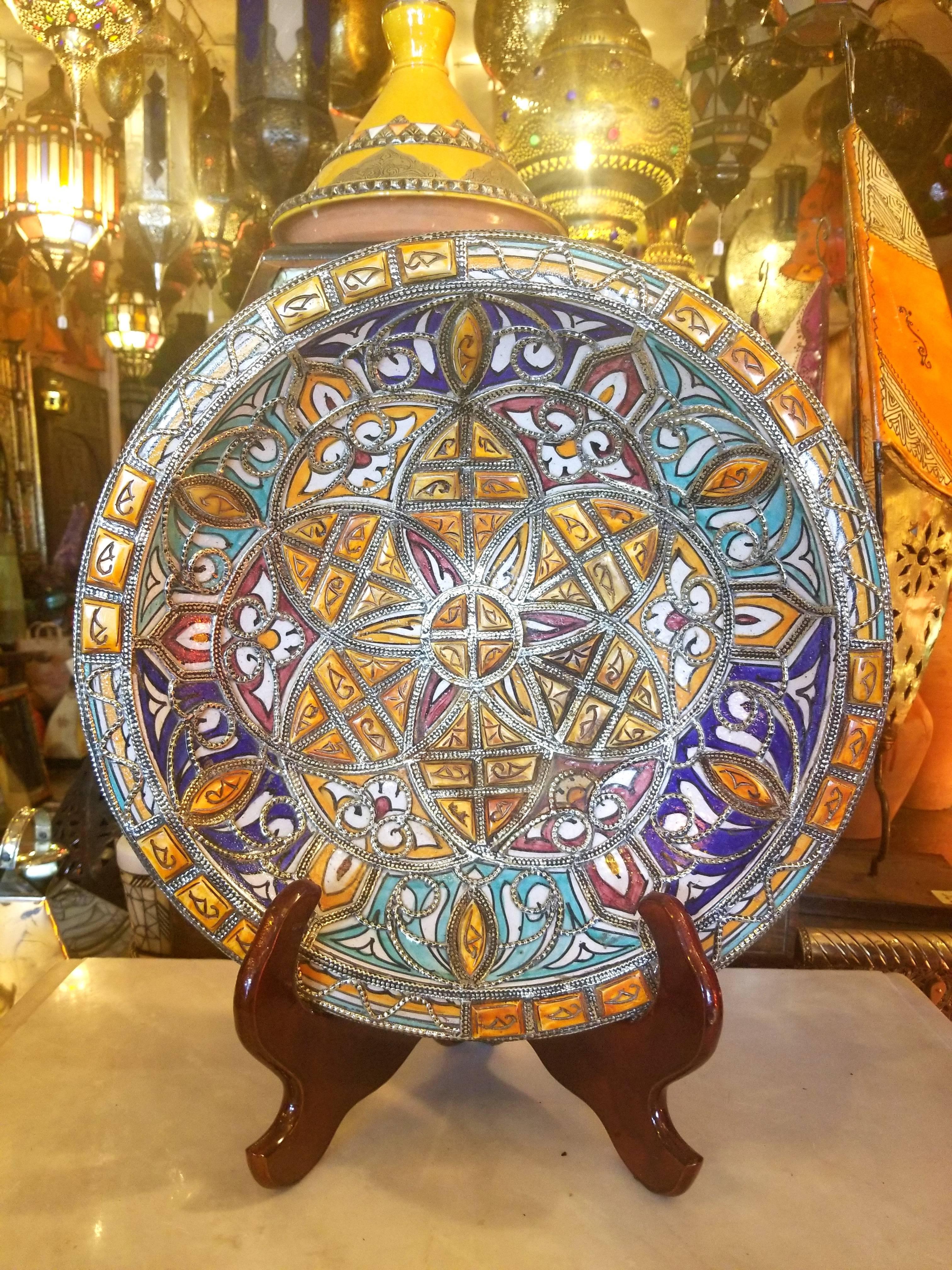 A rare or one of a kind multi-color exquisite Moroccan plate / charger for decoration purpose only. It is hand-painted, and inlaid with metal. Henna dyed Camel bone fragments throughout. This plate would be a great add-on to any decor. Great