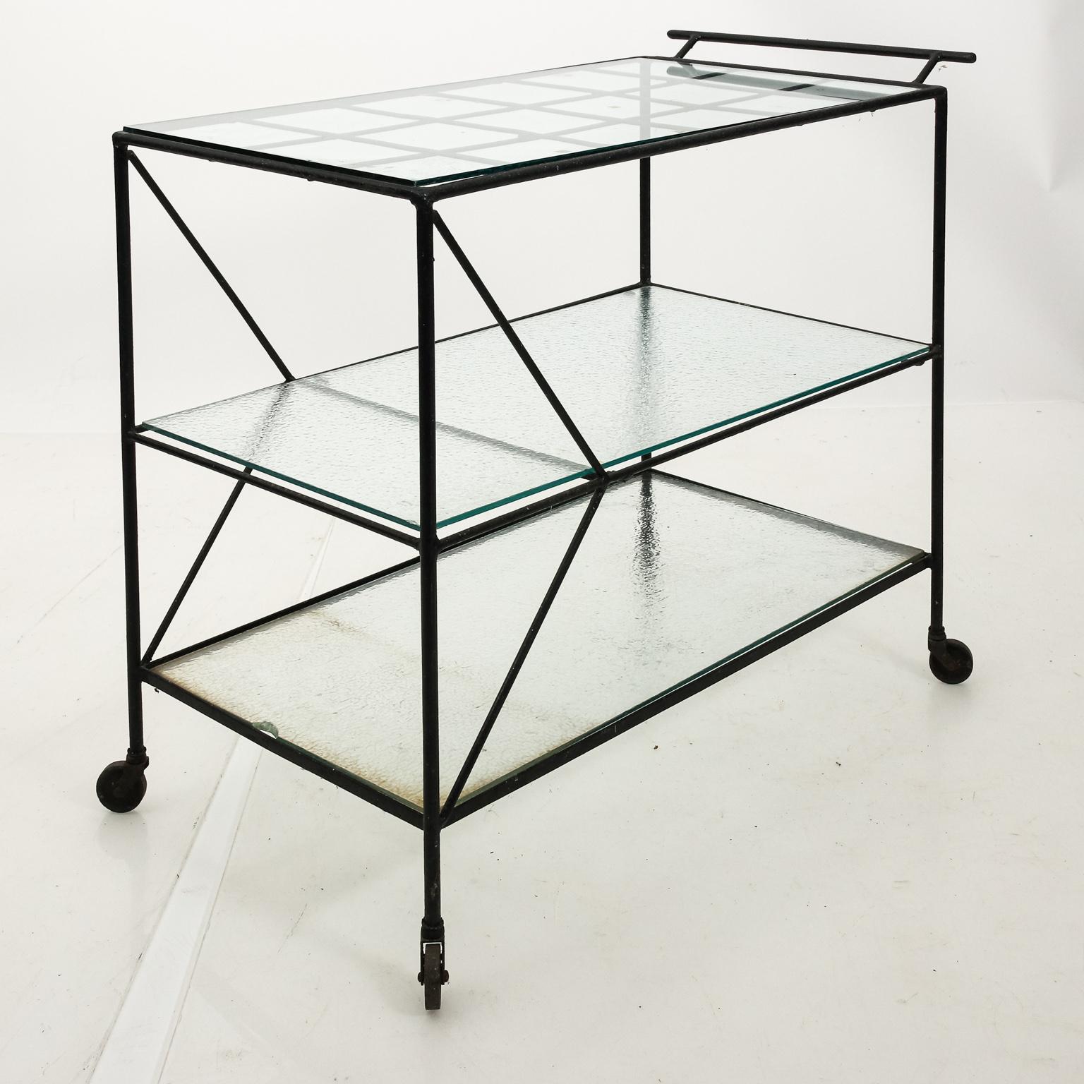 Metal garden or outdoor bar cart by Russell Woodard in the style of Sculptura with glass top. The piece also features three open shelves with one small enclosed shelf.