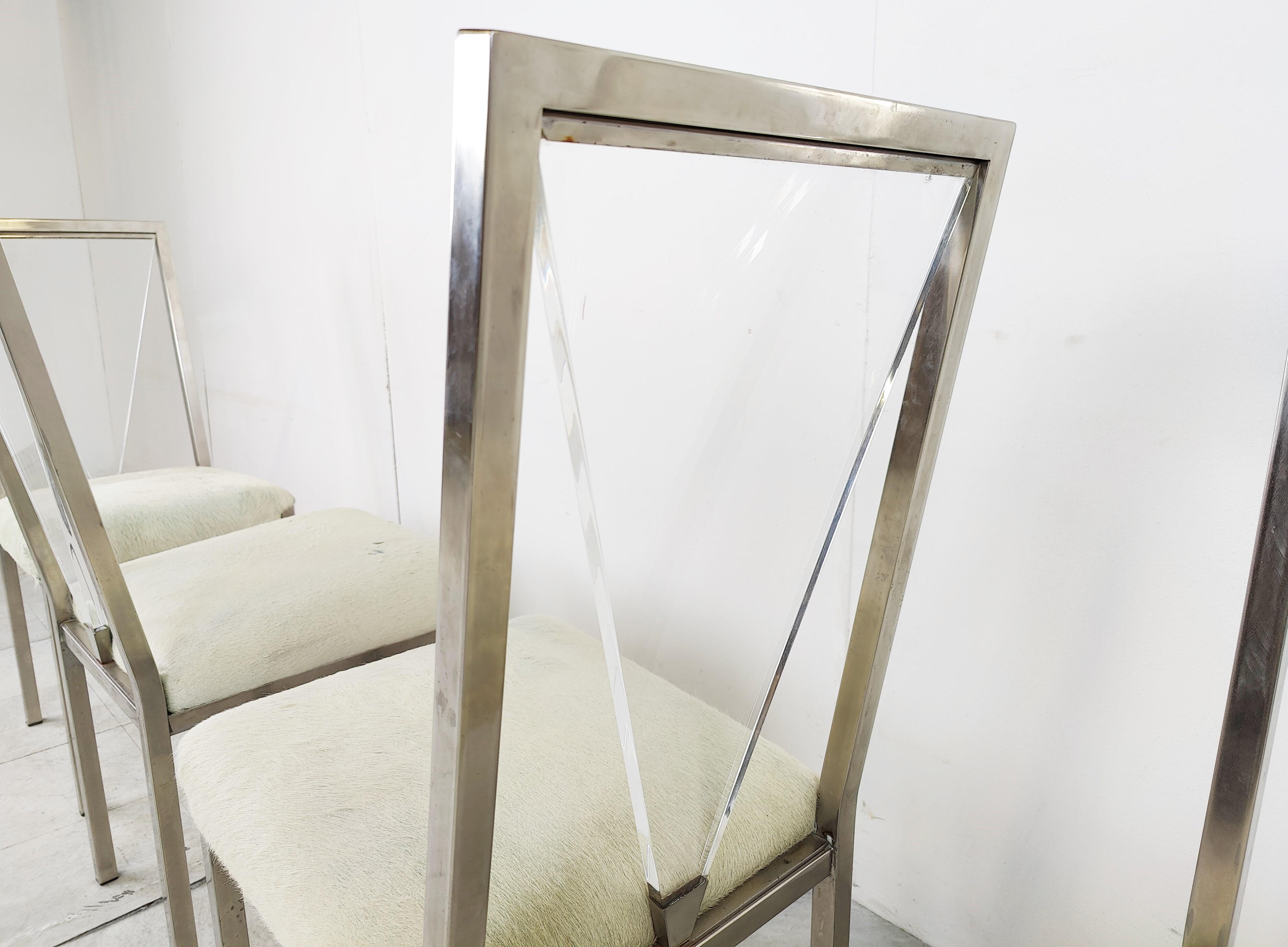 Set of 4 metal and lucite back dining chairs by Belgochrom with ponyhide upholstery.

These chairs bring up the seventies and eighties glam atmosphere back into your home and are of a very good quality. 

Belgochrom used to make top end quality