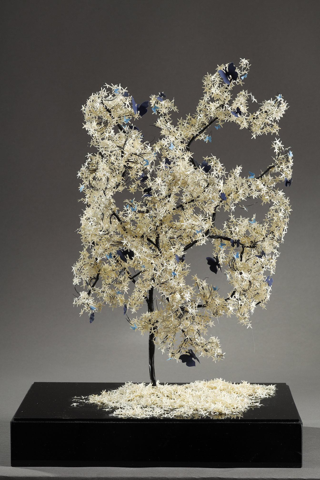 Cette pièce unique de l'artiste libanaise Nayla Tabet est une sculpture d'arbre combinant des fils métalliques de haute qualité et du papier blanc finement découpé, donnant naissance à une œuvre unique en son genre. L'artiste aime explorer le