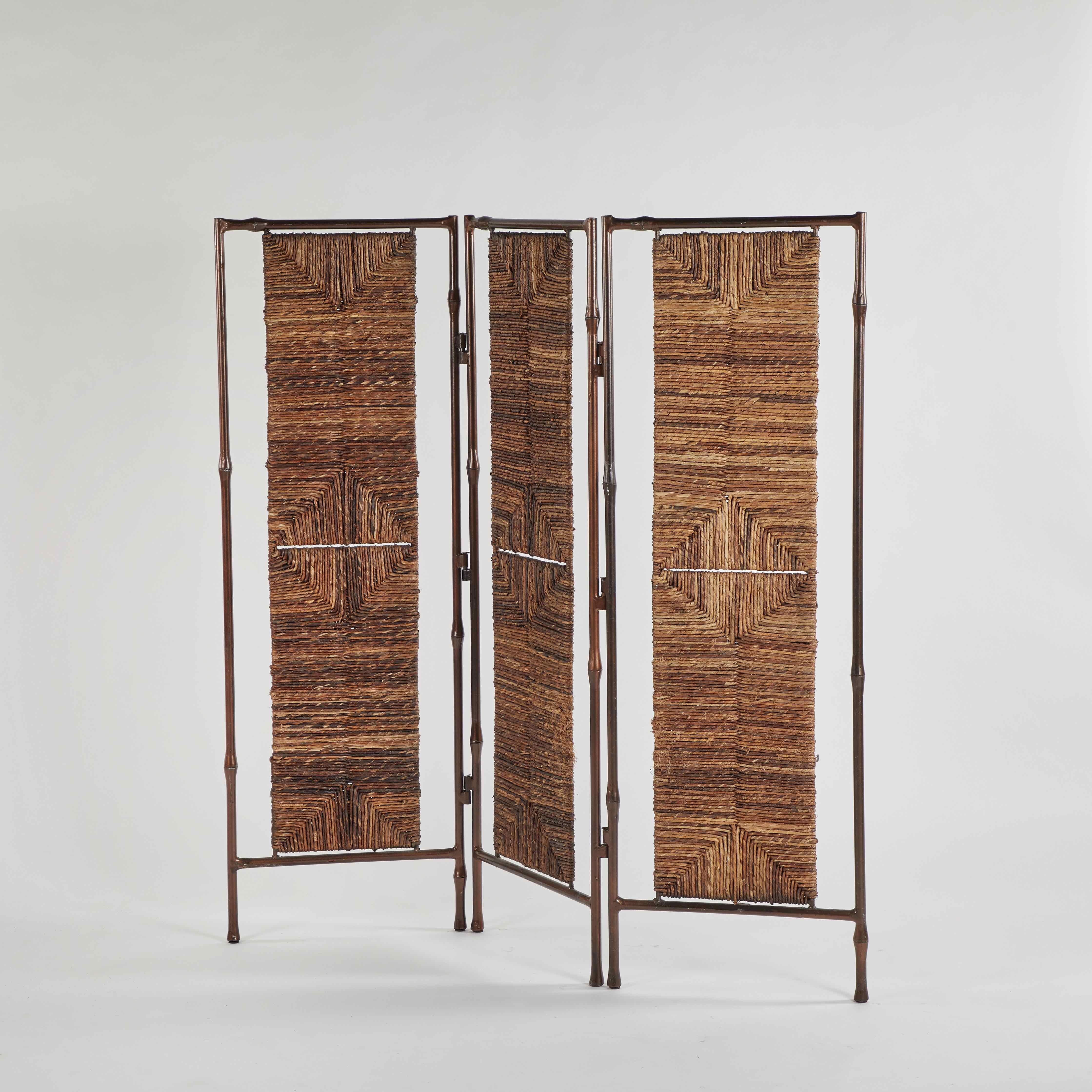 Metal and rattan screen or room divider from turn-of-the-century England. The metal frame is designed to resemble bamboo. The rattan has been woven in a unique graphic geometric pattern. An airy and chic way to break up space. 

England, circa