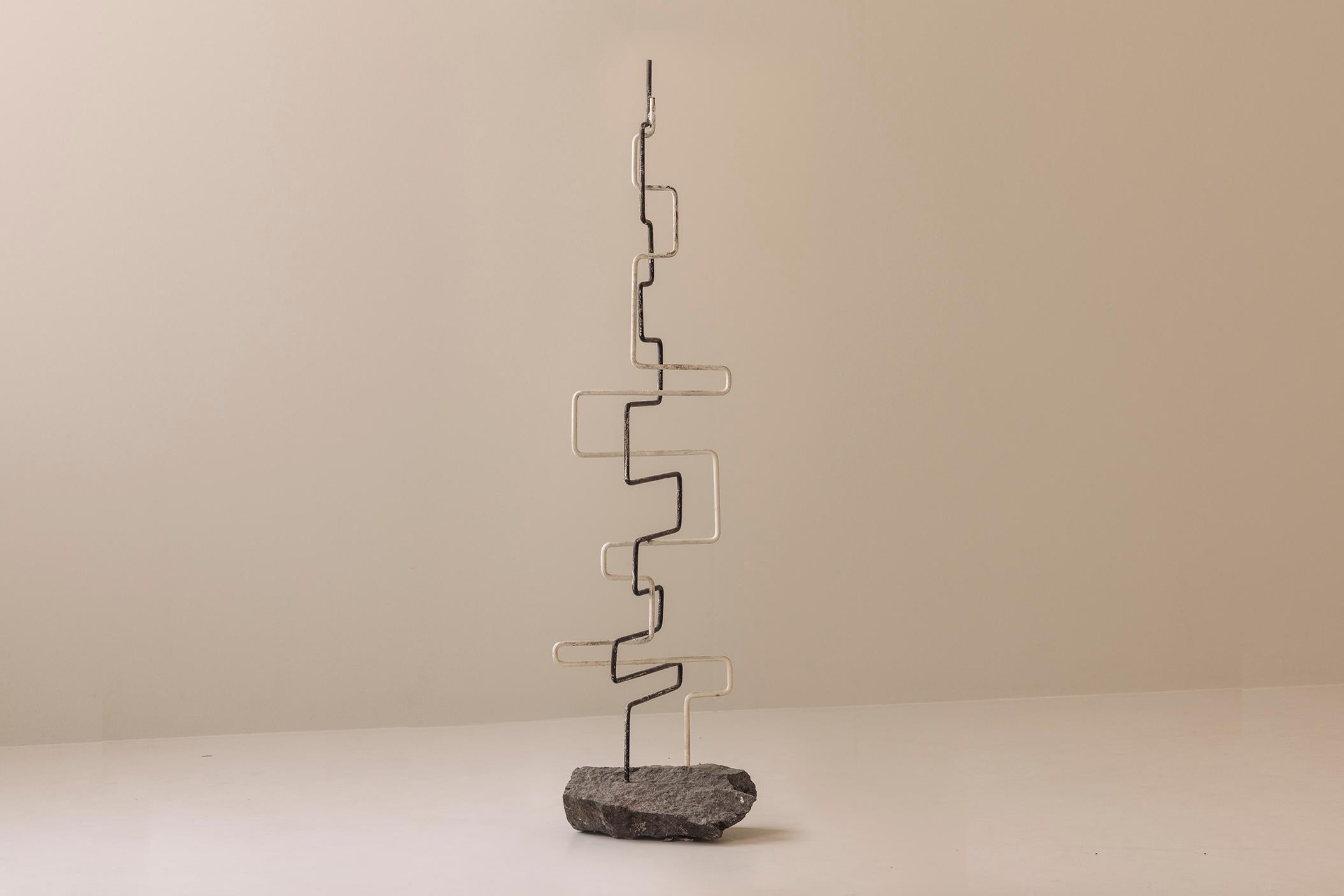 Una scultura enigmatica e architettonica, creata in Francia durante gli anni '60. Sebbene l'artista rimanga sconosciuto, l'opera parla in un linguaggio decisamente modernista: tensione, ritmo e contrasto elementare. Forgiata in metallo saldato e