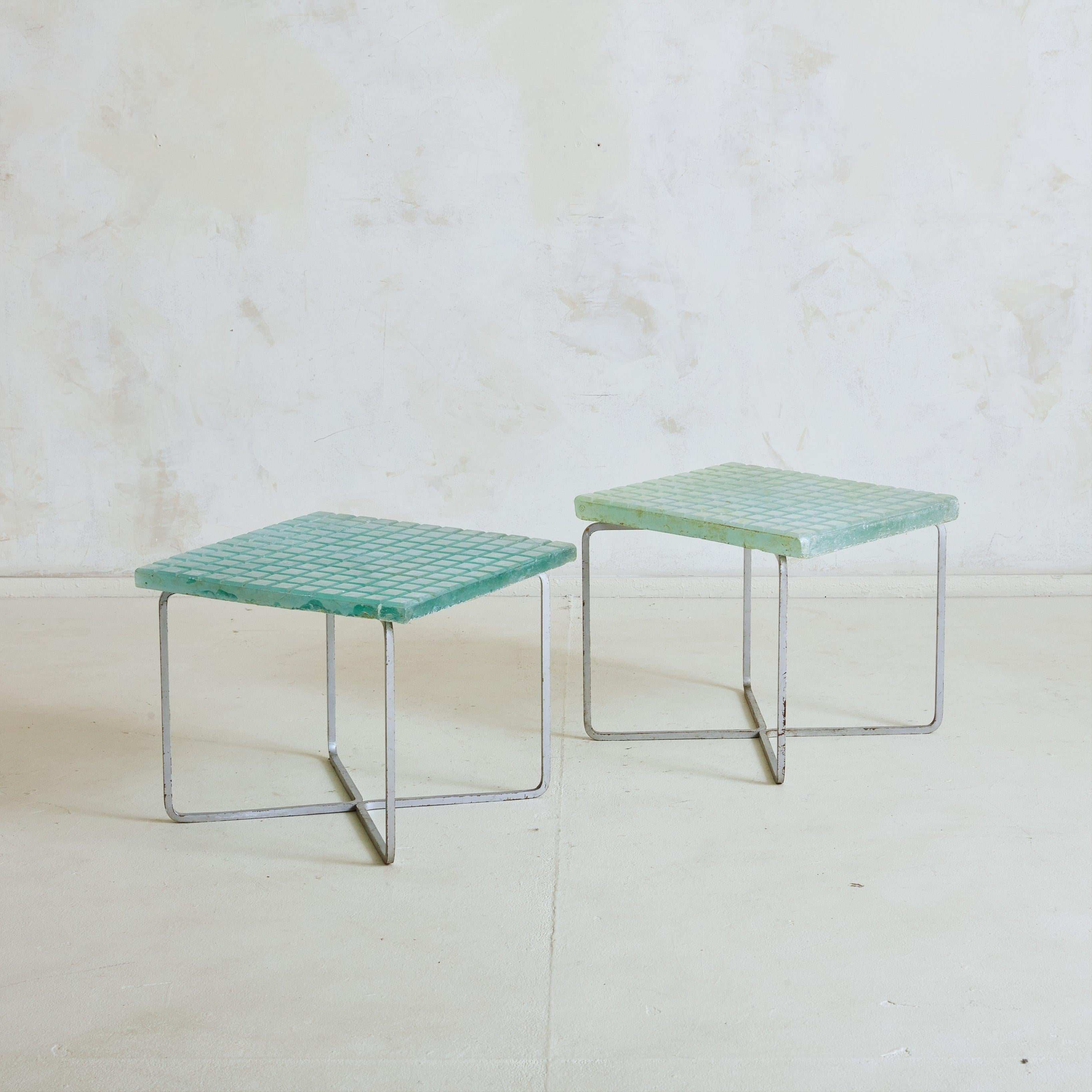 A 1960s Modernist rectangular side table sourced in the South of France. The aqua hued, frosted glass top features a chiseled geometric motif – giving the piece captivating texture. An ‘X’ base frame, composed of patinated metal, effortlessly