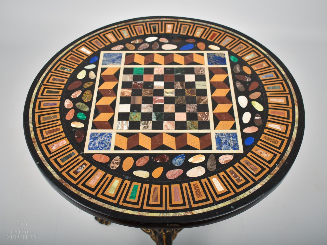 Metal based circular inlaid with semi-precious agates and stones to form a decorative games table to the top. Circa. 1900. The pedestal is a decorative iron painted column with three legs. An unusal and rare item. 