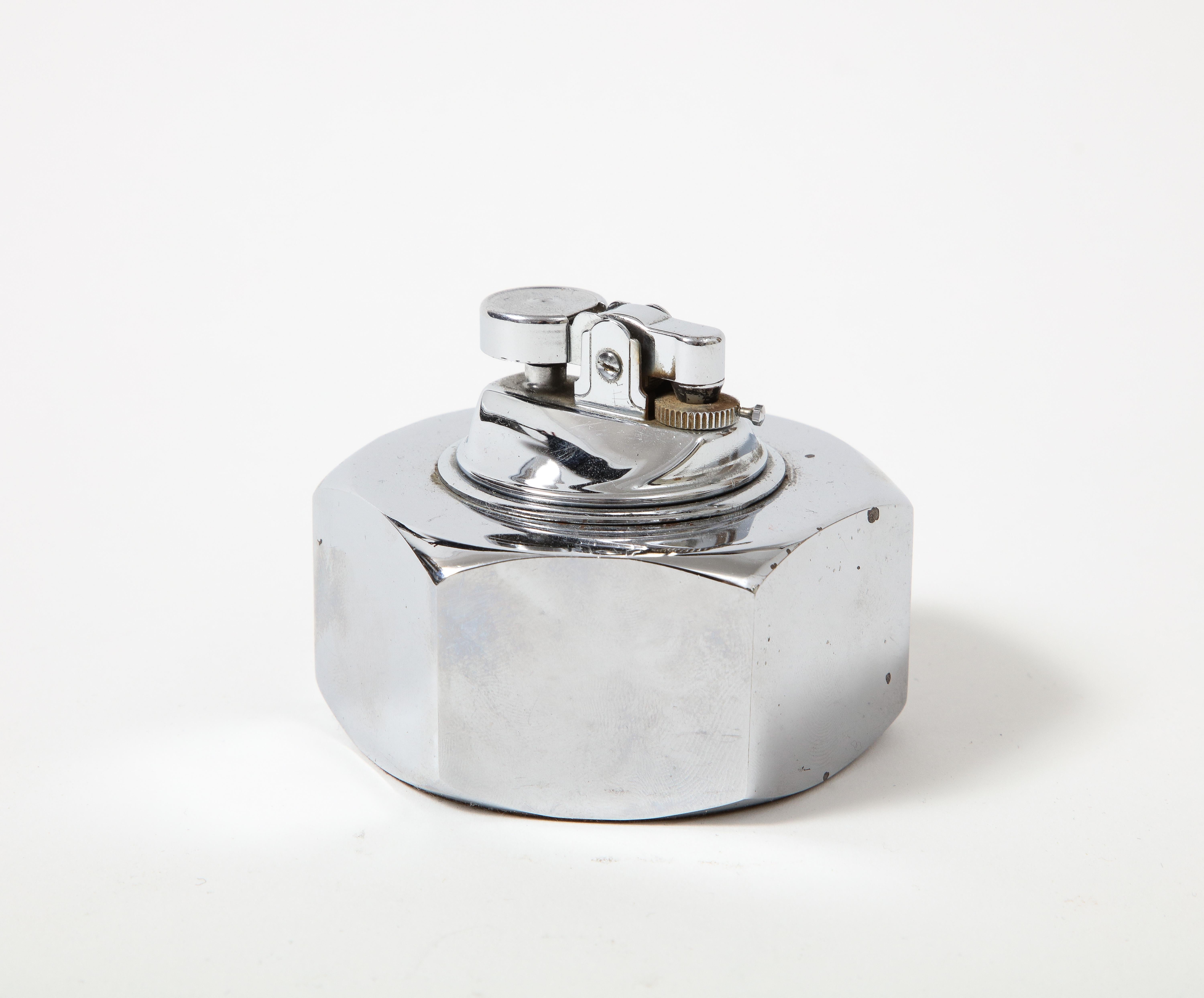 Chromed, polished table lighter in the shape of a bolt. 