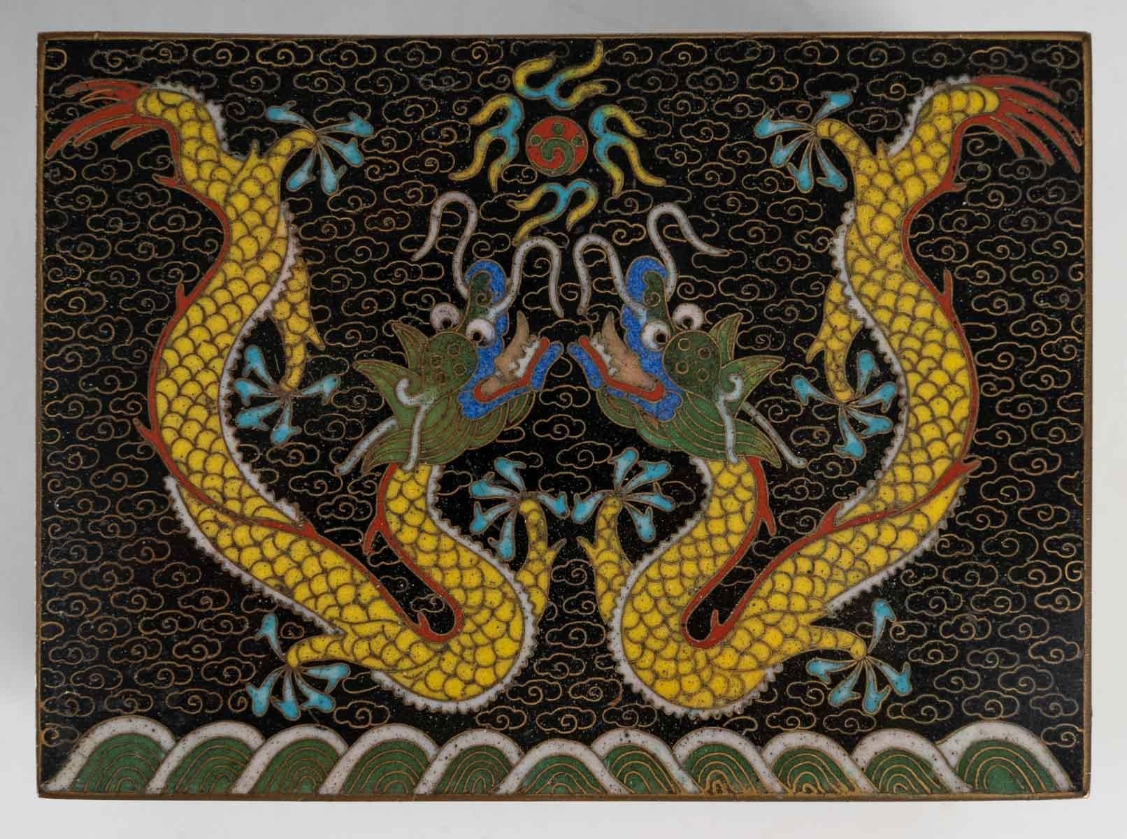 Metal box decorated with cloisonne enamels.

Two dragons facing each other around the pearl of wisdom. 

Turquoise blue enamelled interior.

China. Circa 1920.

Measures: H: 7.5 cm, W: 11.5 cm, D: 8.5 cm.