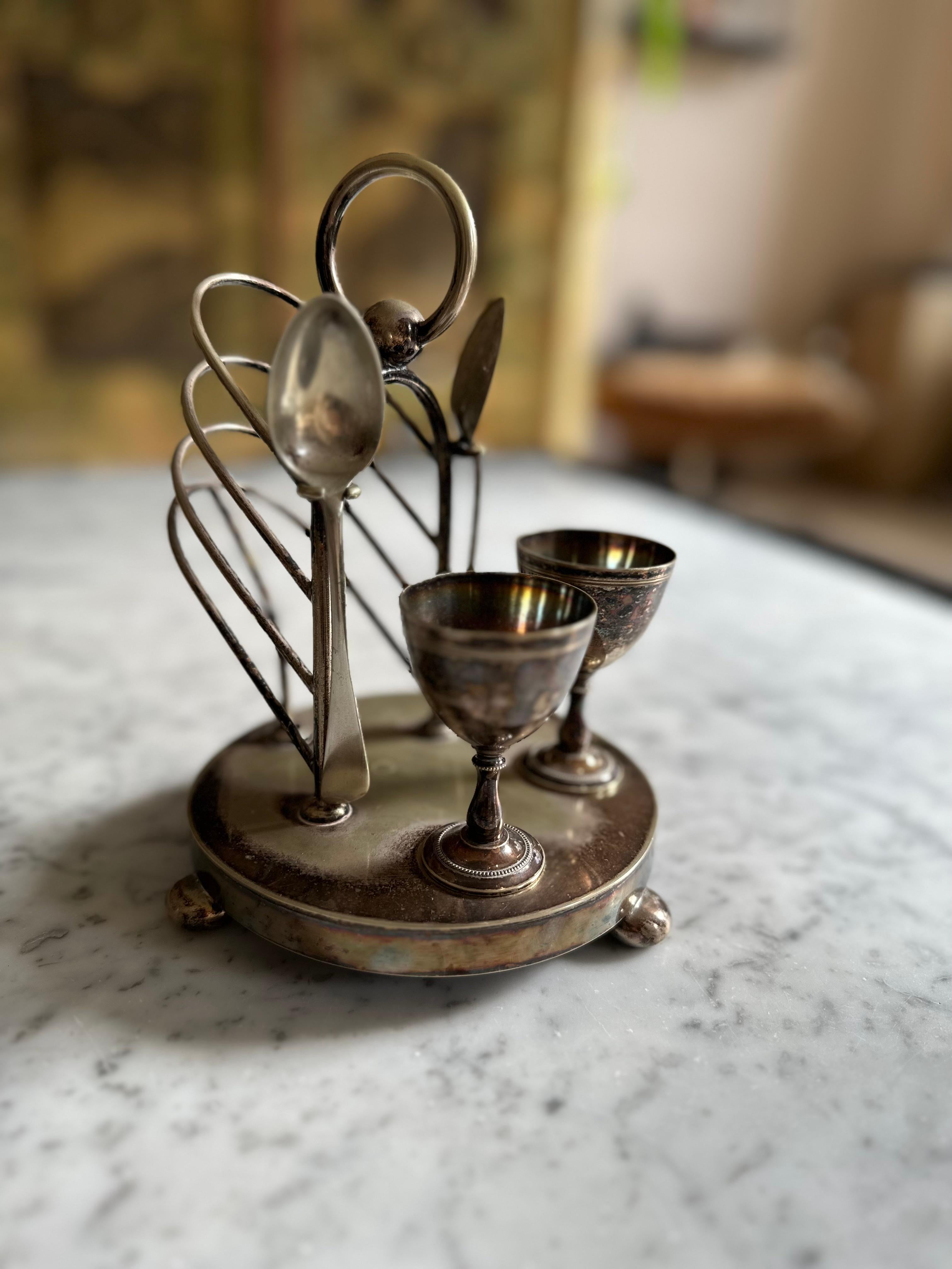 Introducing our charming Breakfast Caddy with Egg Cups, a delightful relic from the early 20th century that adds a touch of vintage elegance to your morning routine. This unique menagerie combines both functionality and aesthetics in one captivating