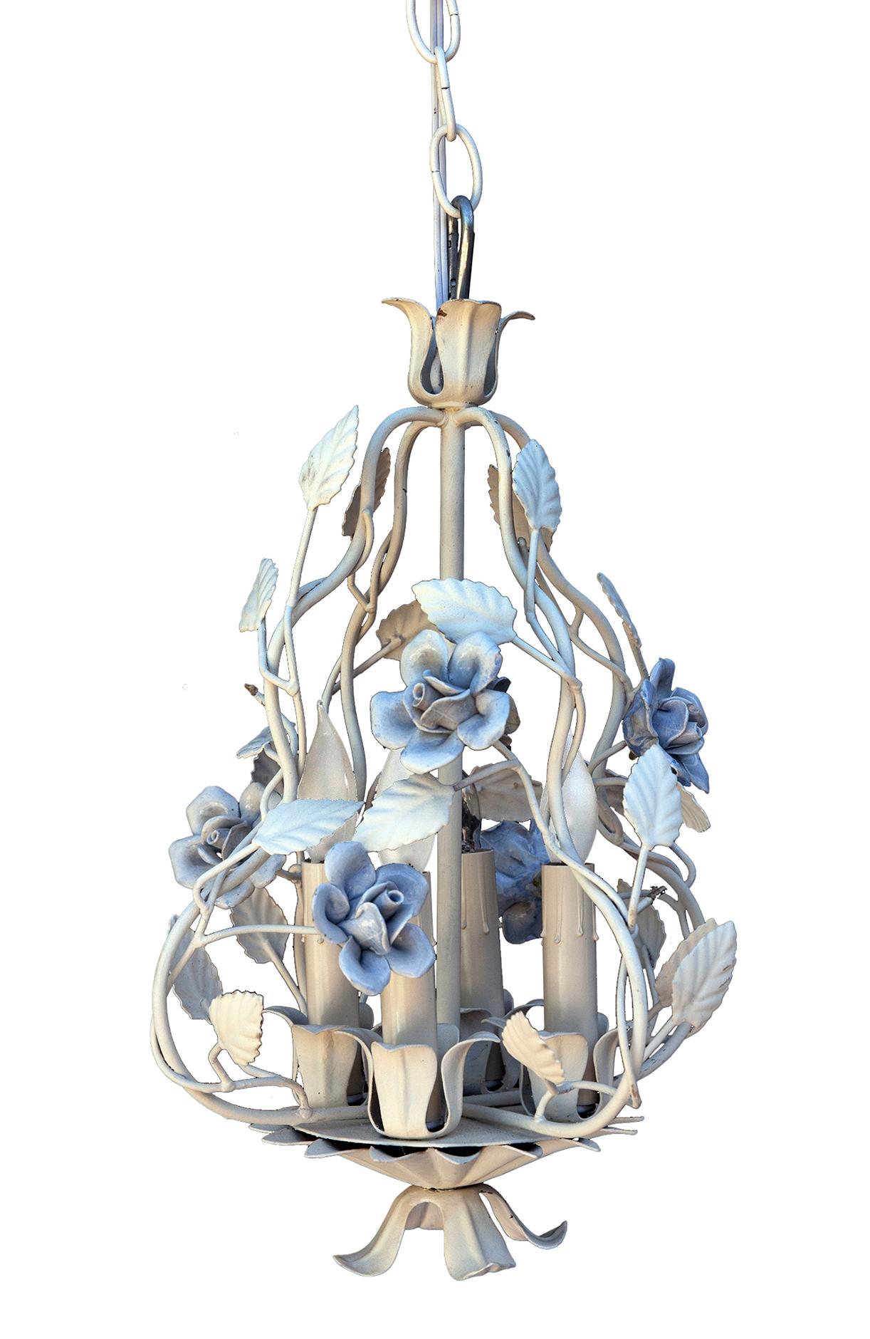 Un lampadario a tole con fiori di ceramica blu fiordaliso. Su ogni petalo fatto a mano ci sono le impronte delle dita. 
Cornice in tole di metallo appena verniciata con rami e foglie, il tutto in un bianco nitido. 
Ricablato con un interruttore e