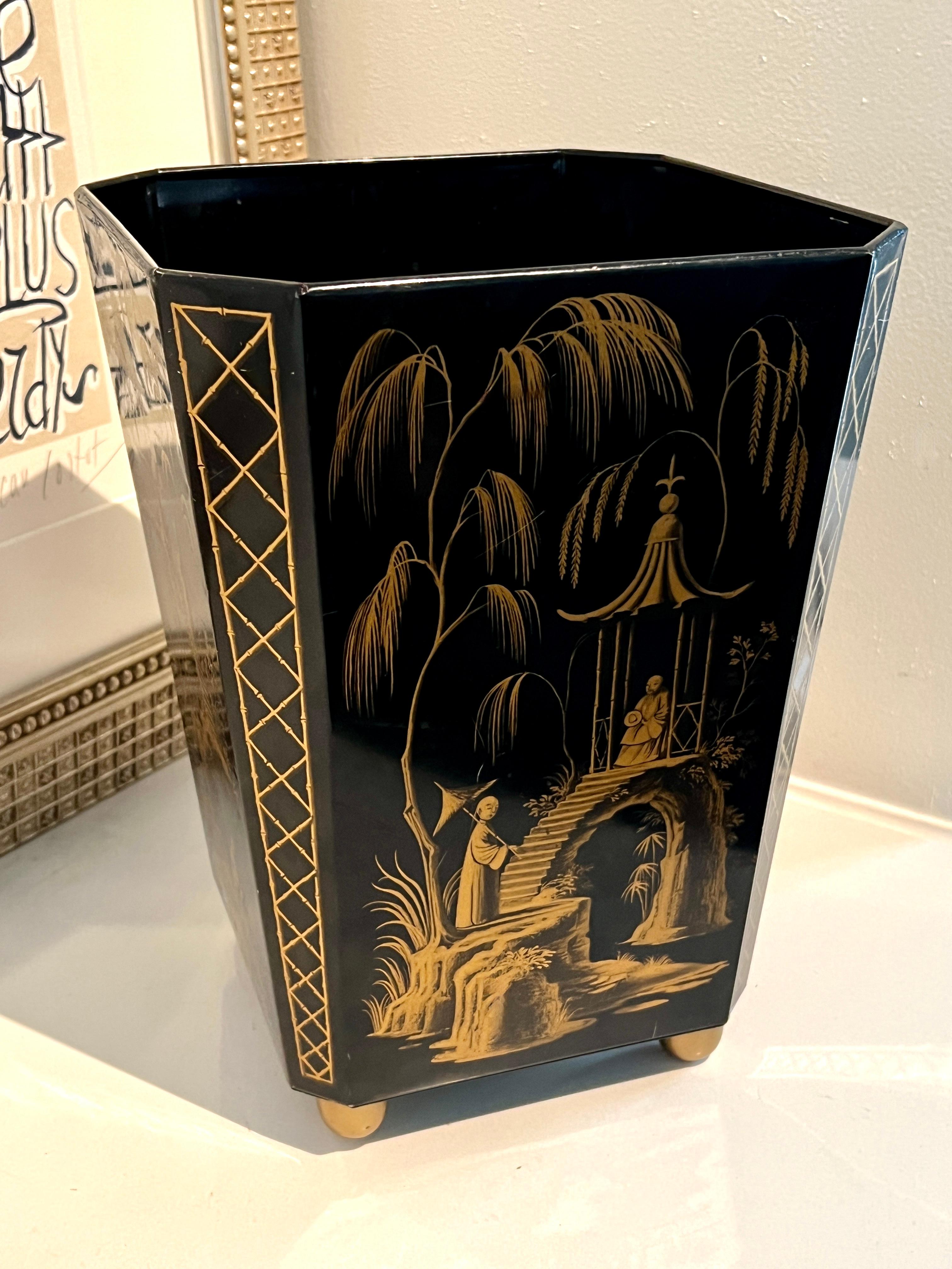 A lovely metal waste or trash can.  The can has a chinoiserie story that works itself around the piece.   A black field with gold imagery.

A wonderful piece and nice compliment to many spaces and especially the powder room, office, or guest