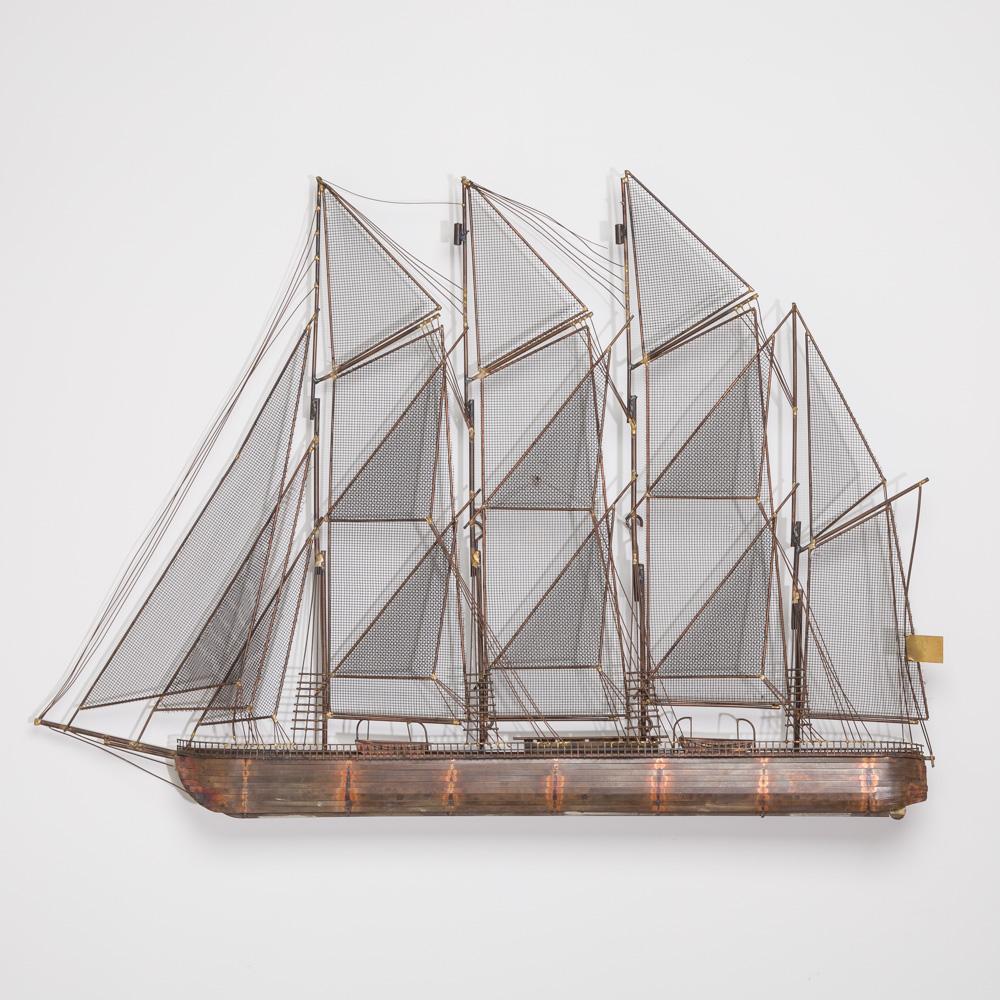 A metal wall sculpture of a brig under full sale by Curtis Jere, signed and dated 1975.

Curtis Jeré is the collaboration of two metal sculptors Jerry Fels and Curtis Freiler who founded the company Artisan House in the USA in 1963. These two