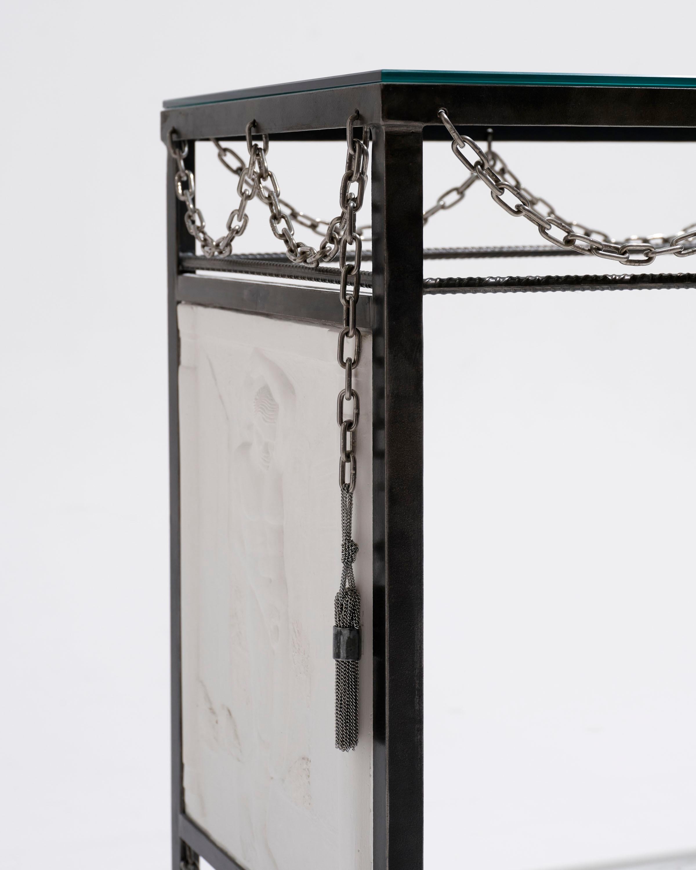 Console or desk in brushed and patinated steel, adorned with garlands of stainless-steel chains and hand-sculpted plaster bas-reliefs, by artist Jordan Joevin, 2024.

Artist’s signature on the back of the bas-reliefs.

DESIGNER: JORDAN JOEVIN