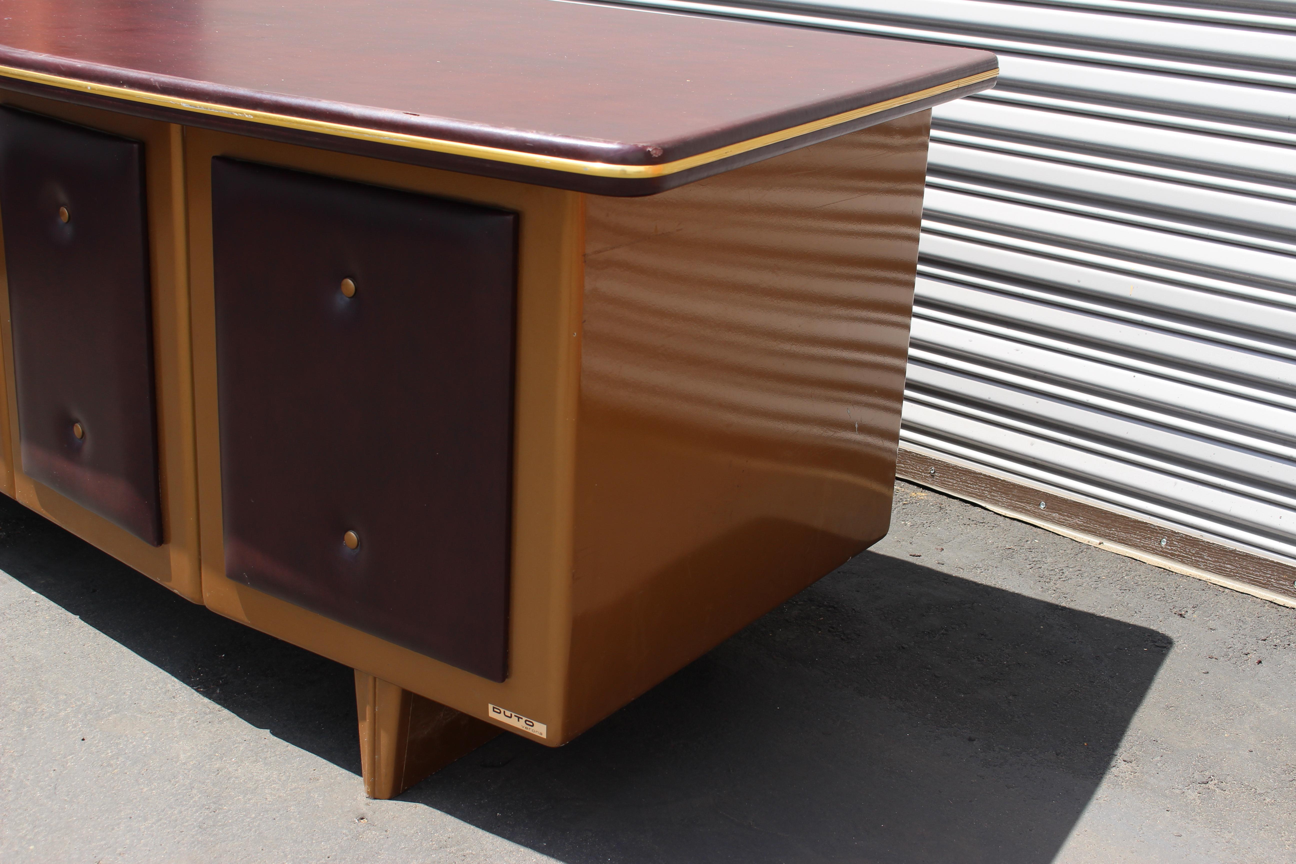 Italian metal desk, 1960s by Duto. Metal desk with the vinyl top and the some vinyl in the front .Antique gold color on the metal and the Burgundy vinyl on the front and top.