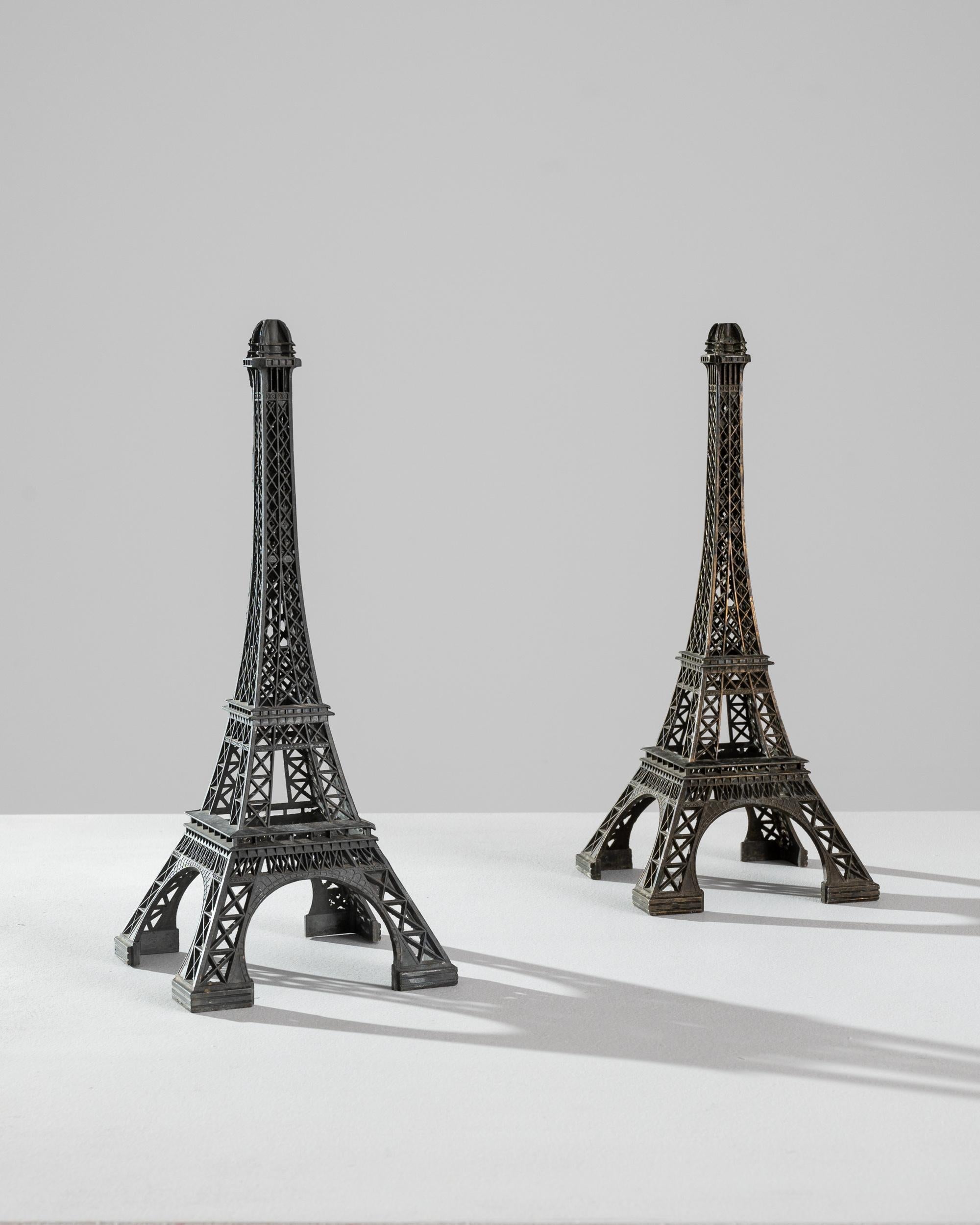 This pair of brass decorations in the shape of the Eiffel tower conjures the romance of a voyage to Paris. Made in France in the 20th Century, the intricate lattice-work is rendered in perfect detail, bringing the iconic monument to life. The dark