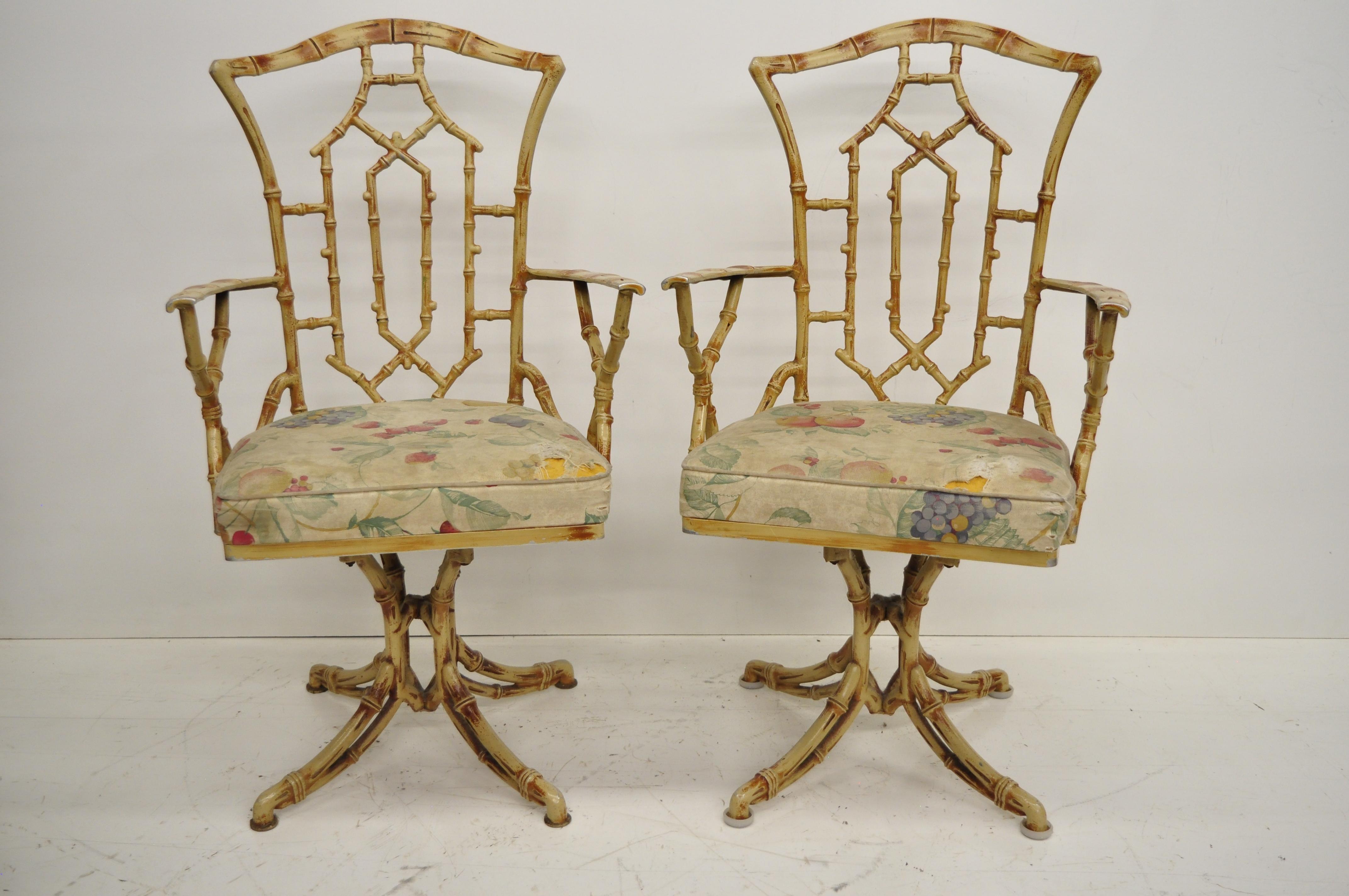 Vintage metal faux bamboo Hollywood Regency / Chinese Chippendale style five-piece dining set with swivel chairs. Listing features two armchairs, two side chairs, pedestal base table with round smoked glass top, swivel seats, yellow finish, great