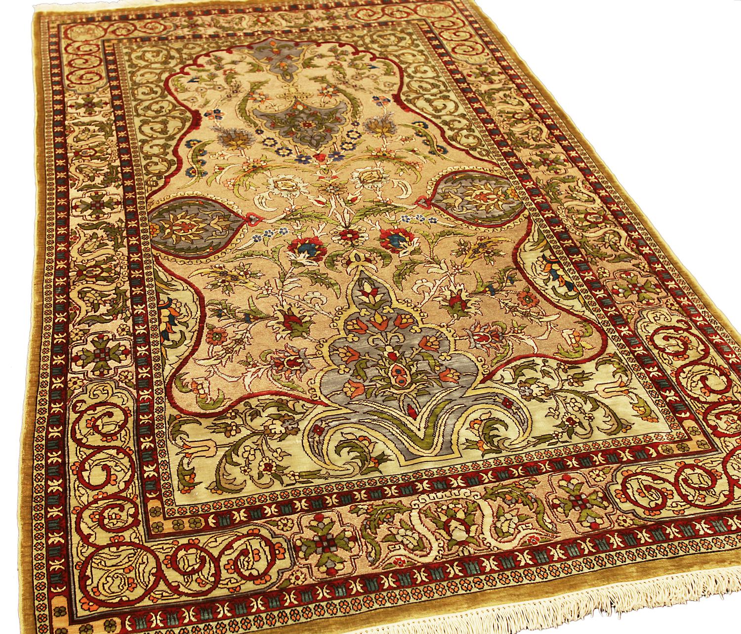 Dies ist ein türkischer Hereke-Teppich mit Seiden- und Metallfäden, der zu Beginn des 21. Jahrhunderts in der Türkei gewebt wurde (ca. 2000-2010) und 150 x 95 cm groß ist. 
Das zartbeige Feld mit gezackten Palemtten, Palettenkartuschen, polychromen