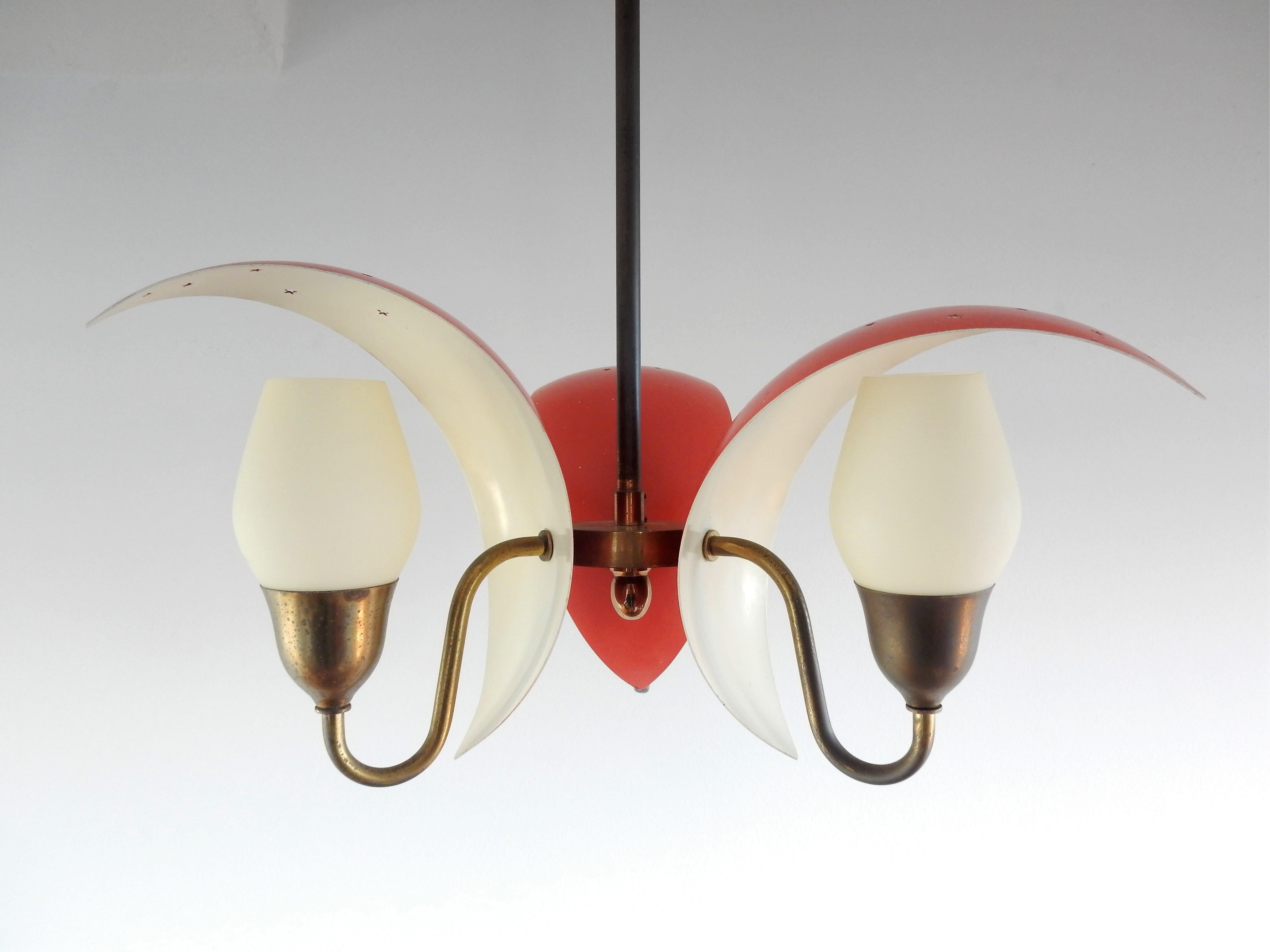 This beautiful small three-arm chandelier has a brass frame and 3 red lacquered metal shades with star shaped perforations. Small opaline glass shades diffuse the light. A very nice design that suits well in a corridor or bedroom for example. It is