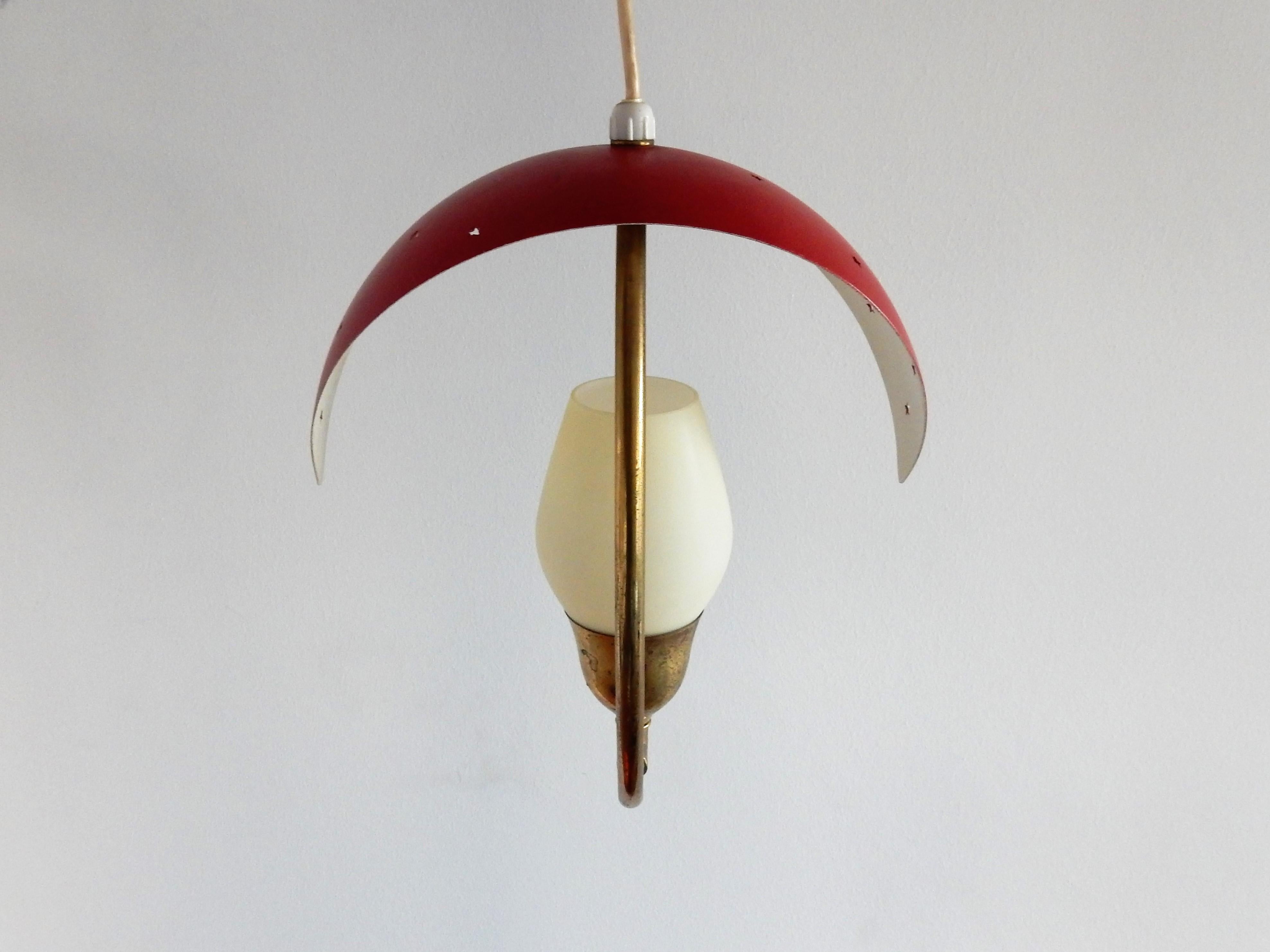 This stunning small pendant lamp has a brass frame, a red lacquered metal shade with star shaped perforations and a small opaline glass shade that diffuses the light. A very nice design that suits well in a corridor or bedroom for example. It is in