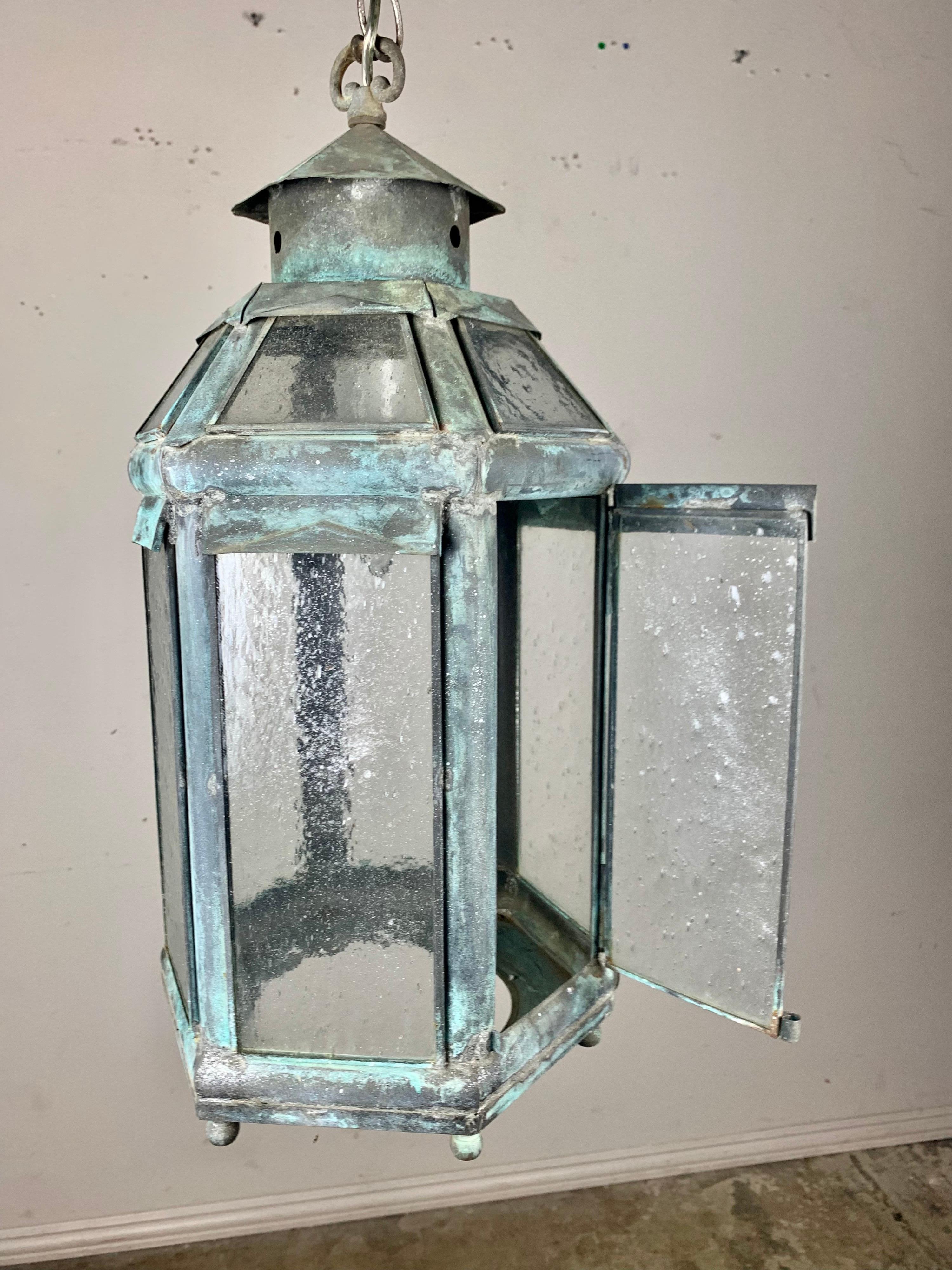 19th c. metal & glass painted lantern that is worn to perfection. The patina is beautiful and the seeded glass add to this unique piece as well. The fixture is newly wired and includes chain & canopy.