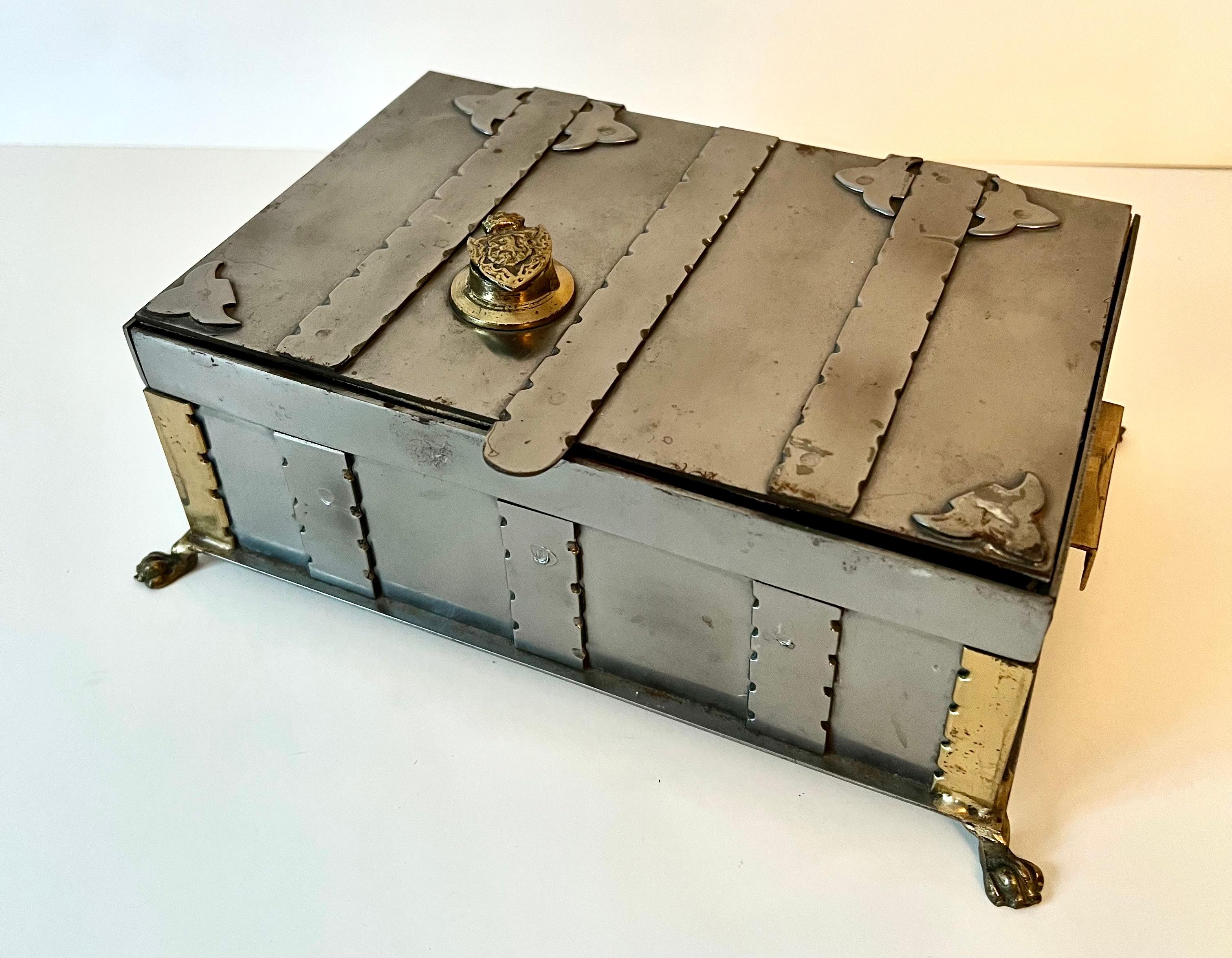 A unique metal box - very durable metal casket style box with velvet inside lining. The box has intricate metal work including the paw feet. A crowned coat of arms marks the twist style lock for the piece.