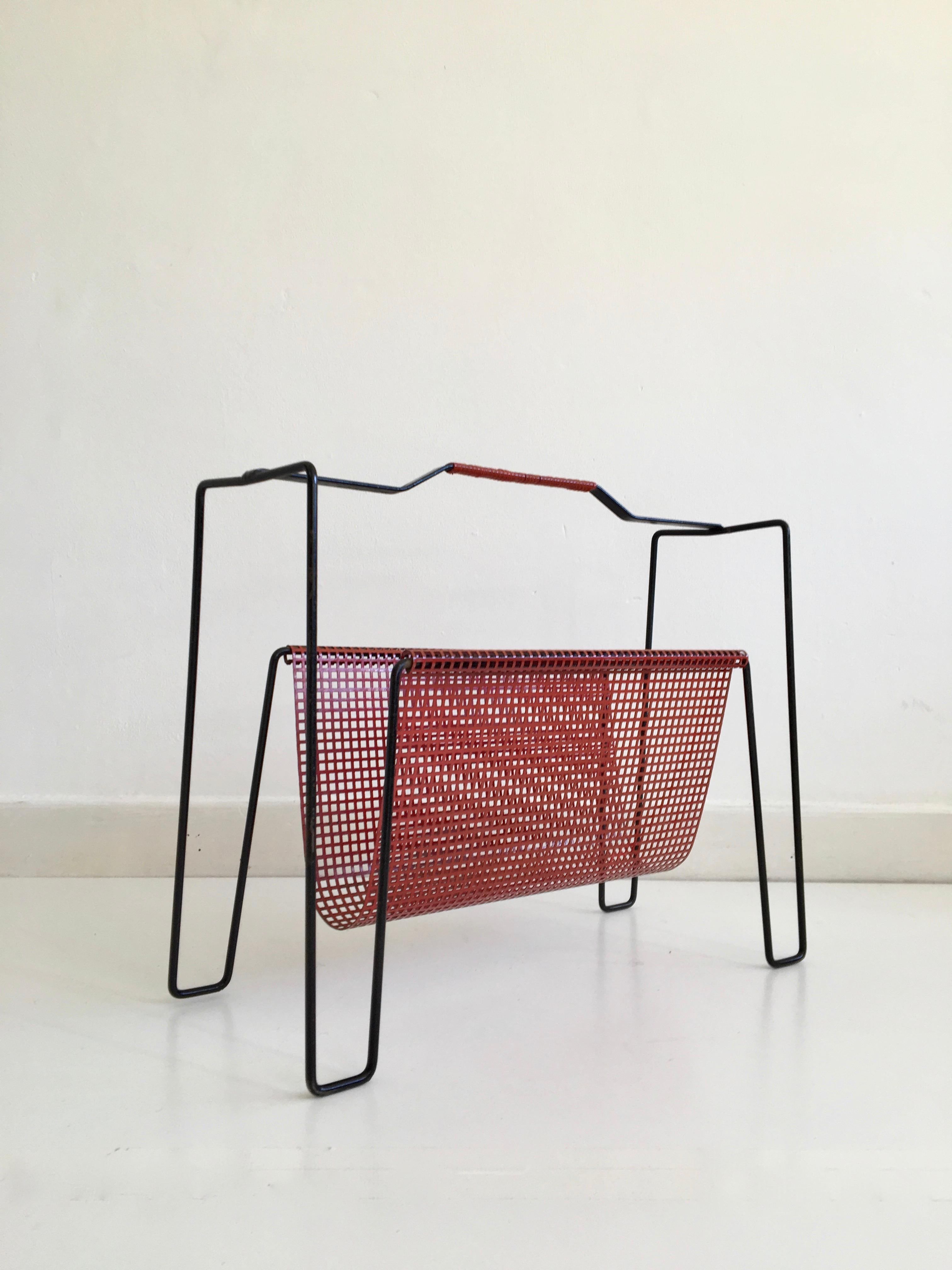 Dutch red and black metal magazine rack designed by Tjerk Reijenga in the 1950s.

Dimensions (cm, approx):
Height 36
Width 45
Depth 19

Good condition for year with minor surface corrosion to the black metal frame.
 
