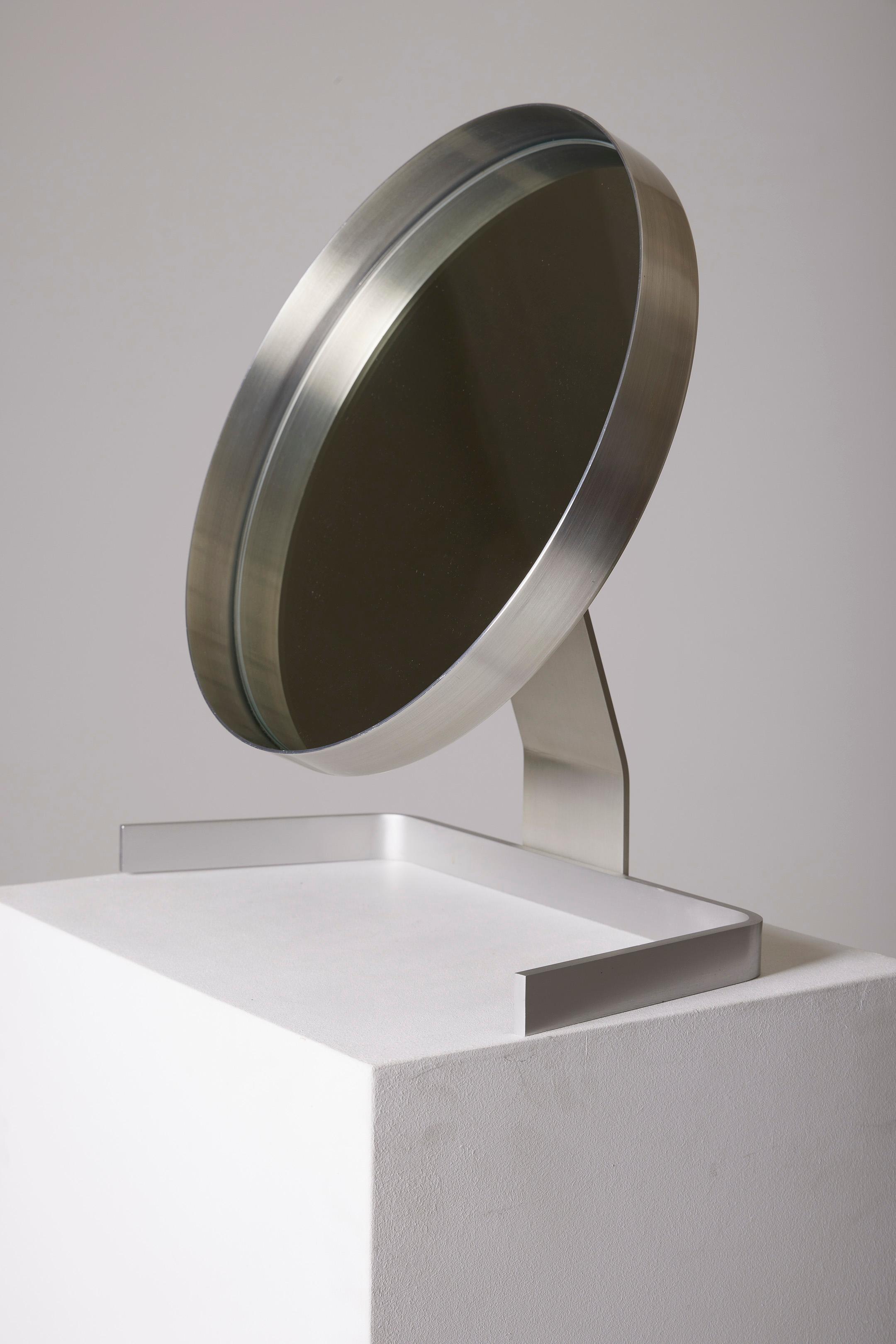 Round brushed aluminum tabletop mirror by French designer Pierre Vandel (1939-) from the 1970s. Following his collaboration with the publisher Marais International, Pierre Vandel founded his own workshop and had a decisive encounter with the famous
