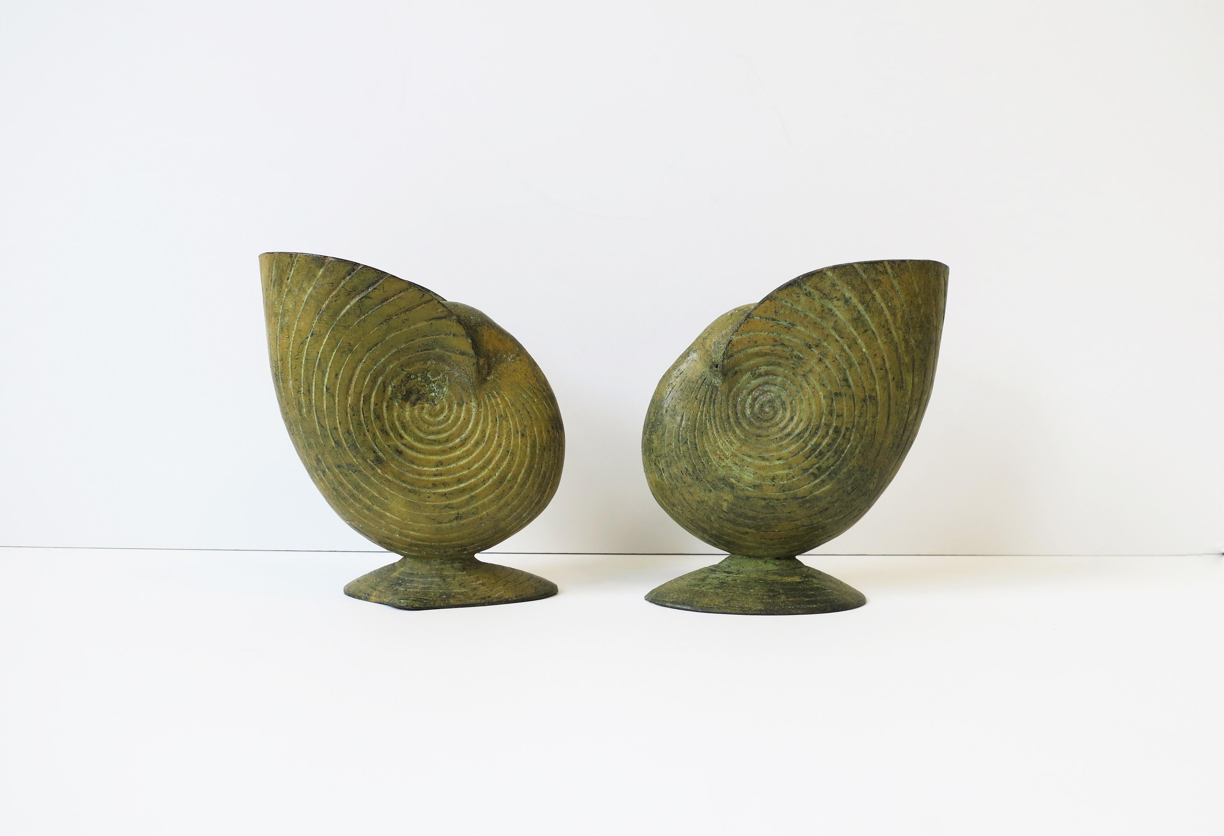 A great pair of mustard yellow metal nautilus seashell vases with clamshell bases, circa late-20th century. Great as standalone pieces decorative objects or as vases (shown with large leaf in image #8.) Dimensions: 6.63