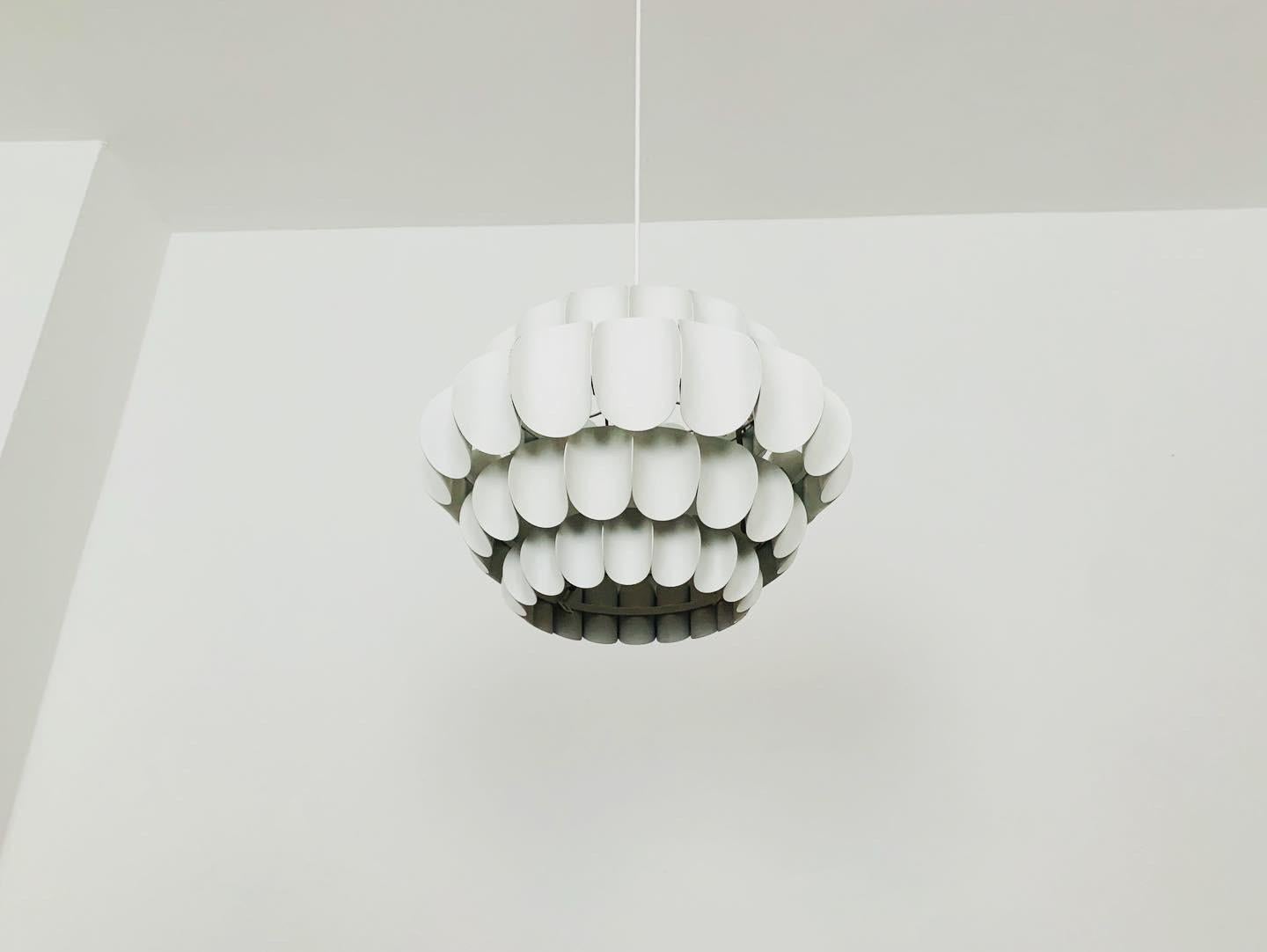 Splendida lampada a sospensione in metallo bianco di Thorsten Orrling degli anni '60.
Lo straordinario design crea un fantastico gioco di luci nella stanza.
Versione rara con 4 file.

Condizioni:

Condizioni vintage molto buone con lievi segni di