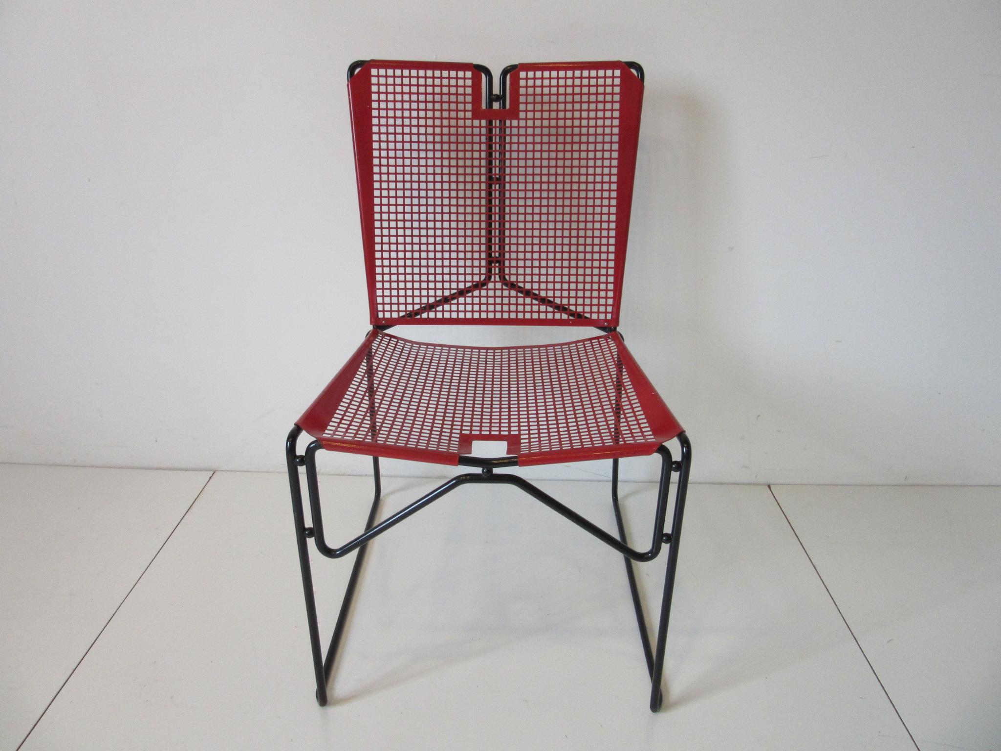 A pair of folded and perforated red and black metal chairs with sculptural rod frames and round ball details . Made in France in the manner of Mathieu Mategot .