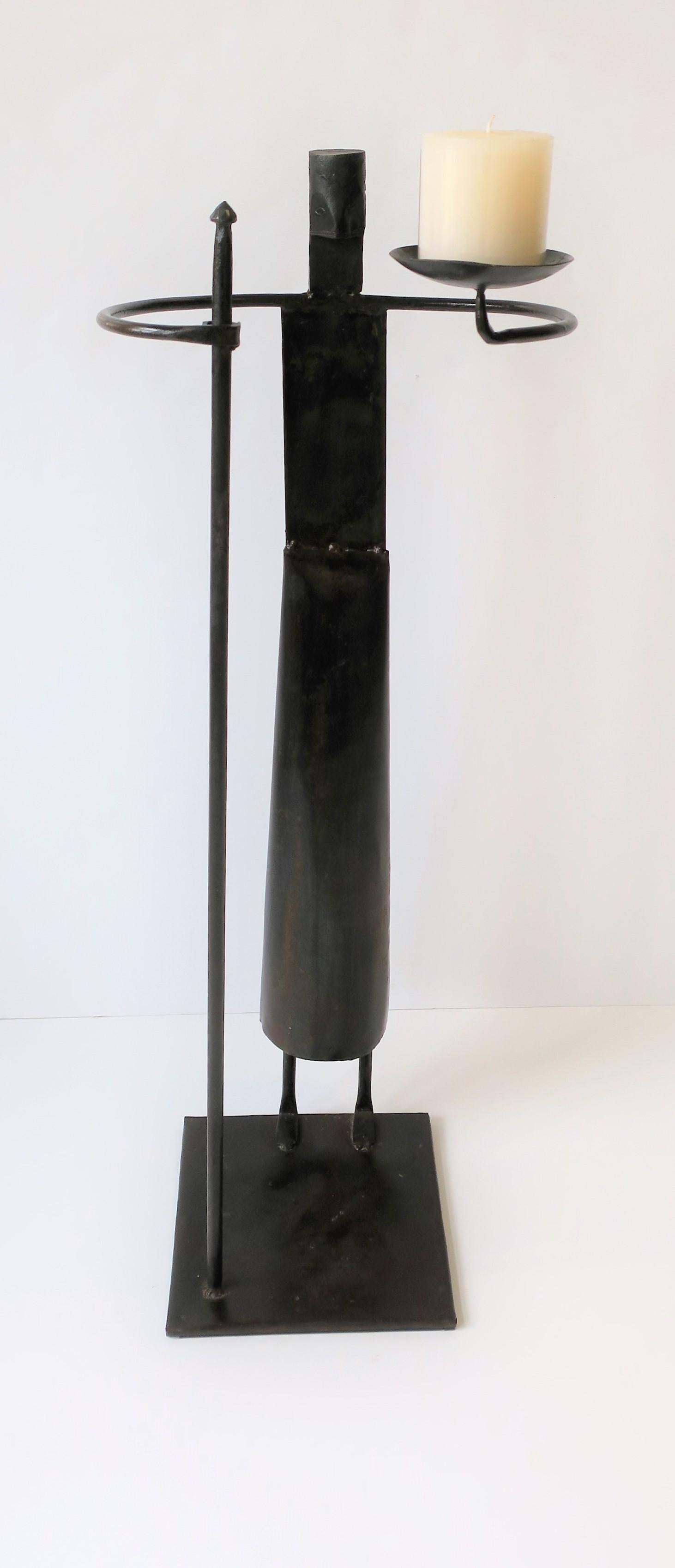 A standing handcrafted indoor or outdoor Primitive or tribal metal sculpture piece with spear and light (candle.) This a special handcrafted metal figurative sculpture piece, a 'warrior' of sorts, that could work well indoors or outdoors (patio,