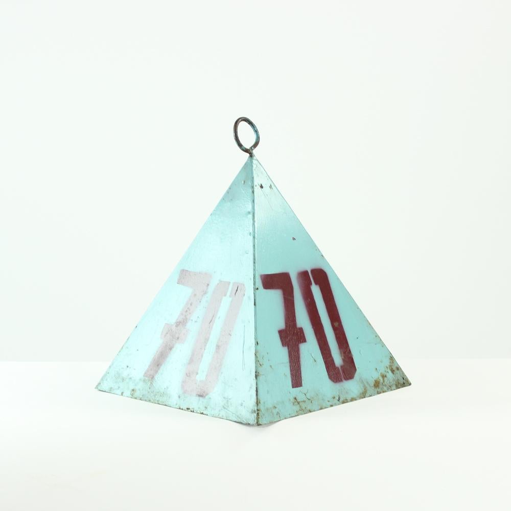 Ein seltenes Accessoire mit einer wahren Geschichte. Eine Metallpyramide, die seit den 1940er Jahren auf einem Sportplatz in der Tschechoslowakei als Messinstrument verwendet wurde. Das Feld war für Ball- und Backenwerfer bestimmt. Die Pyramide ist