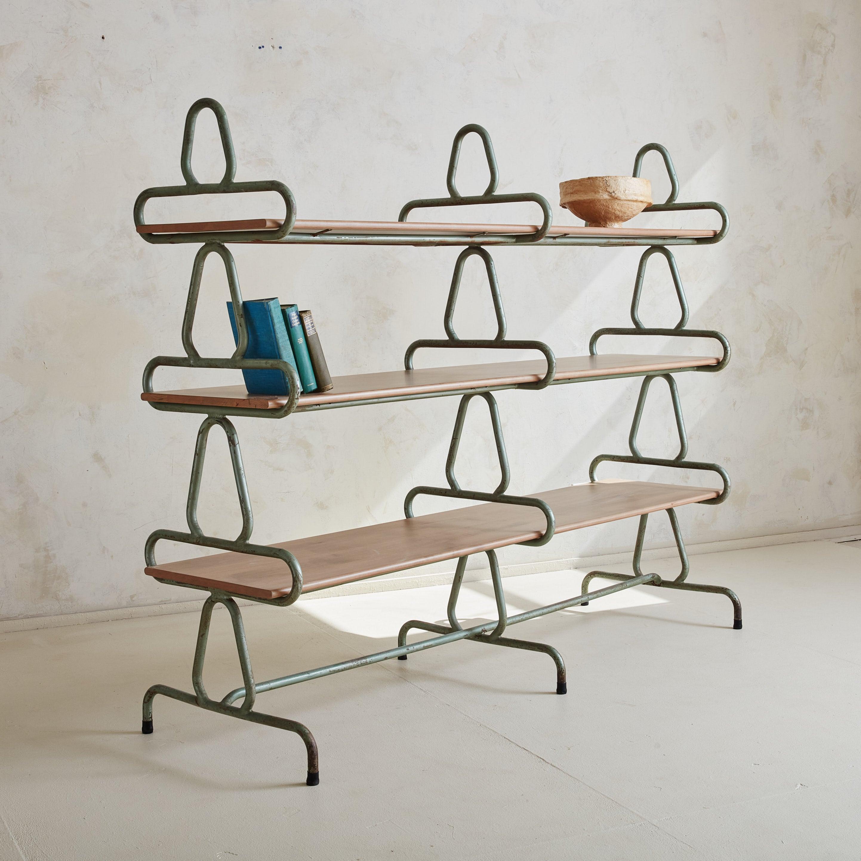 Estantería escultórica francesa de los años 50 con una preciosa estructura de metal patinado en verde menta natural. El diseño se caracteriza por una forma artística y caprichosa con estructuras en bucle que evocan un aspecto ligero y aireado. Se