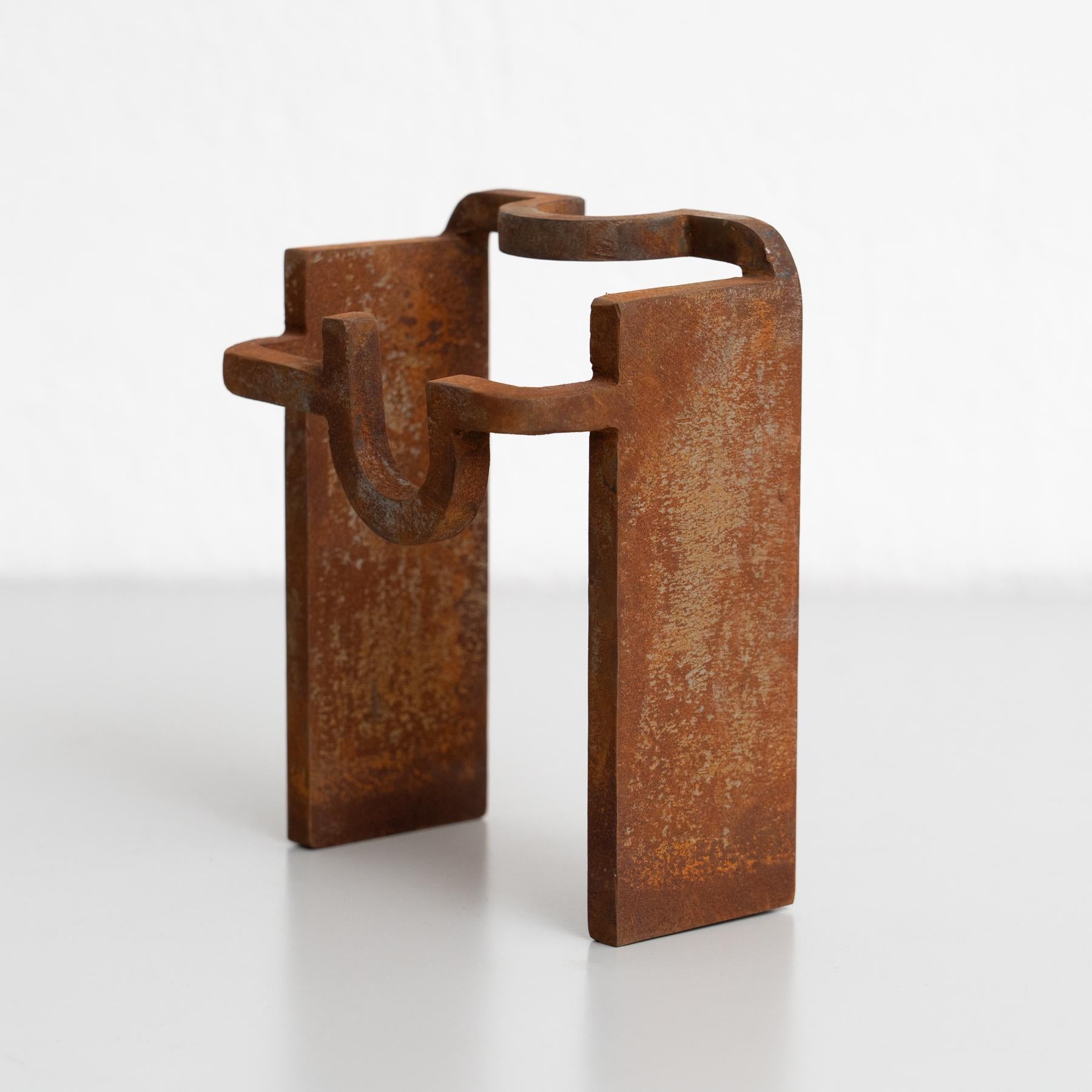 Questa sorprendente scultura in metallo con finitura ruggine è un pezzo unico, ispirato allo stile iconico dello scultore spagnolo Eduardo Chillida. Creato negli anni '90, riflette l'influenza del razionalismo, con linee solide e forme astratte che