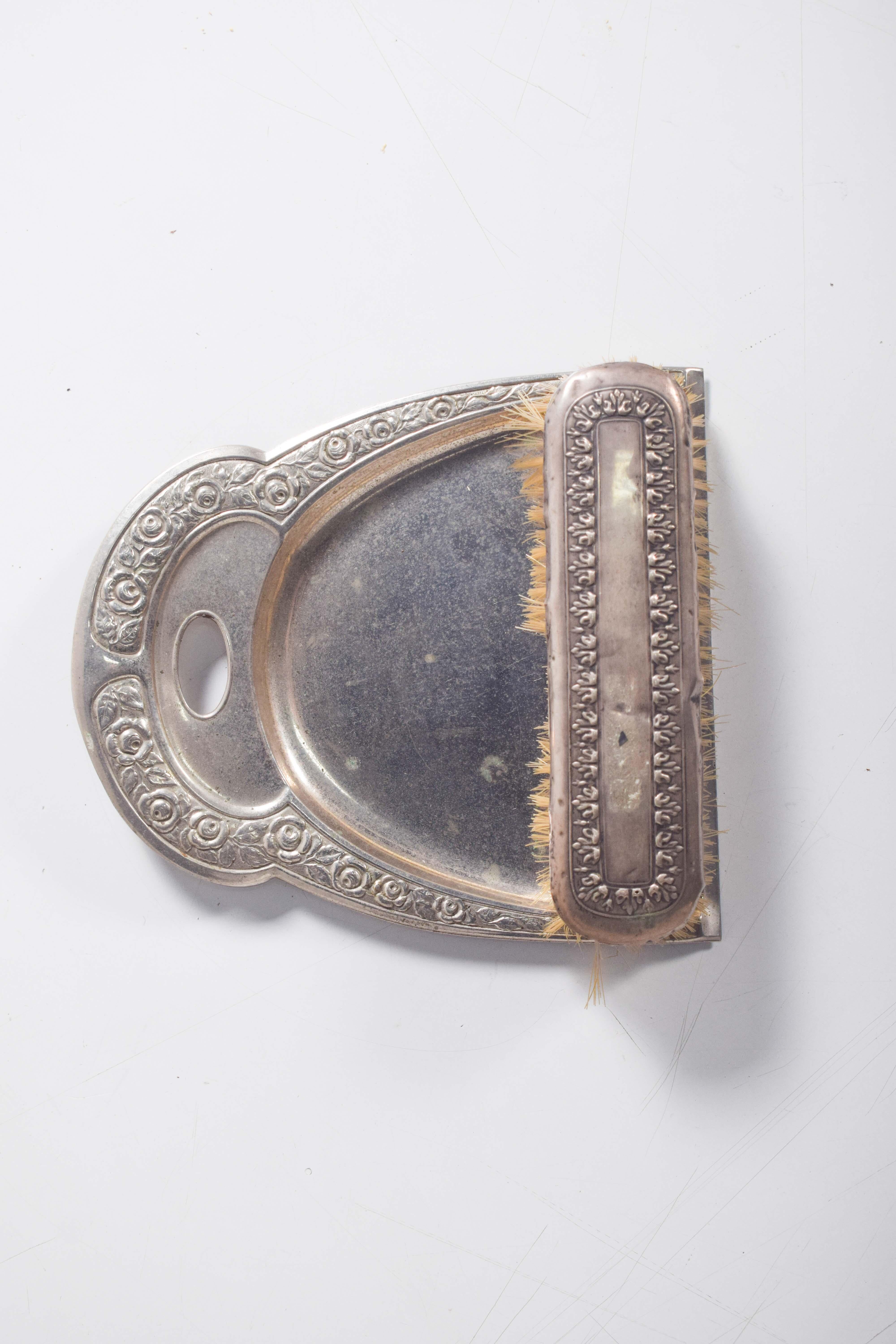 A charming 19th-century shovel and brush set, crafted from metal and other materials. The pieces are adorned with intricate guilloché decoration, featuring elegant floral motifs that highlight their vintage beauty. While showing signs of age with