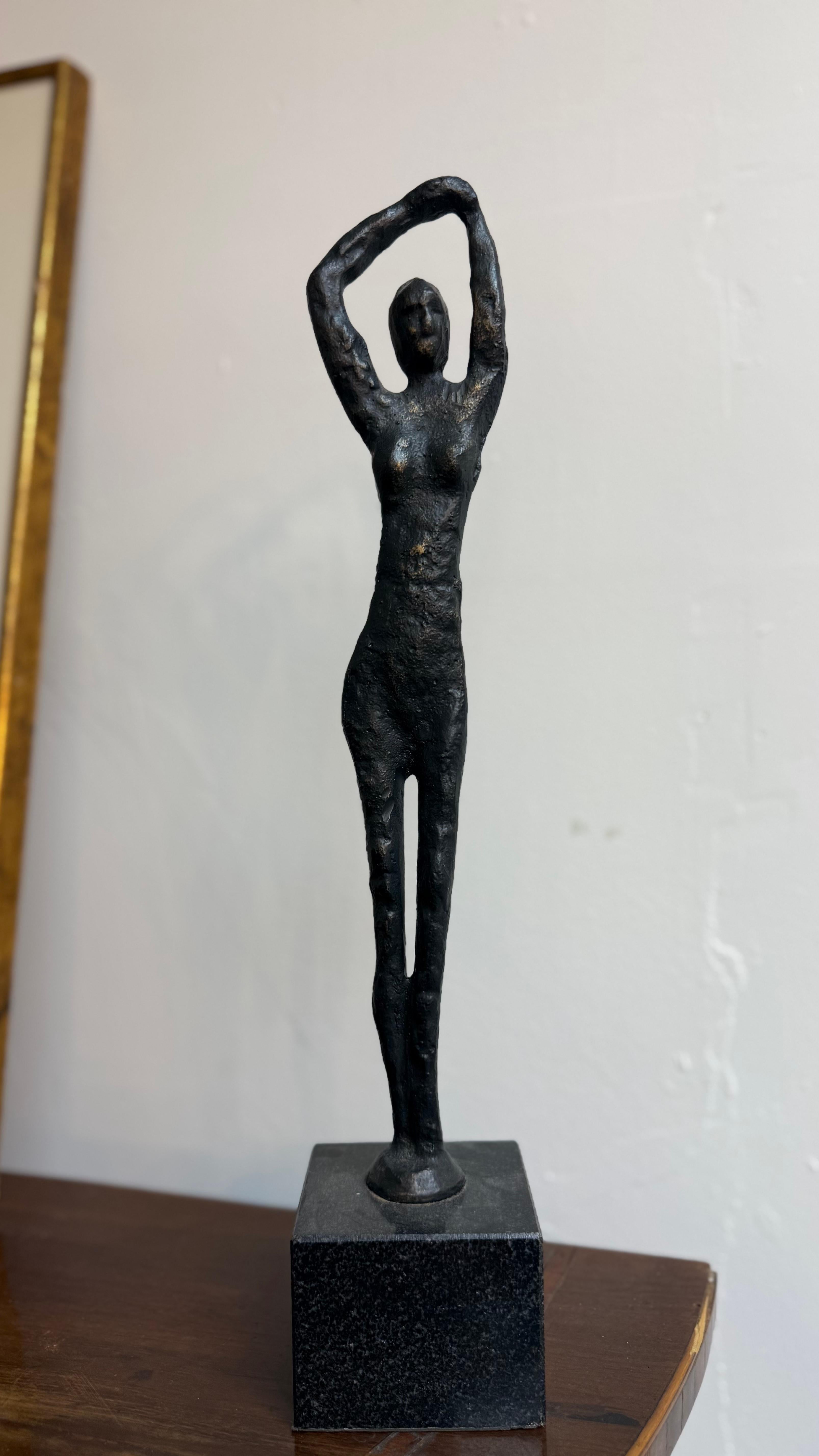 A captivating hand-cast metal female statue featuring a modern abstract form, finished in a rich bronze patina. This sculptural piece gracefully captures the essence of feminine movement and strength through its fluid, minimalist lines. Set atop a